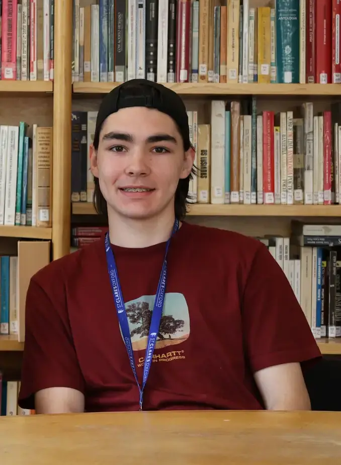 Male student in red shirt sat in library