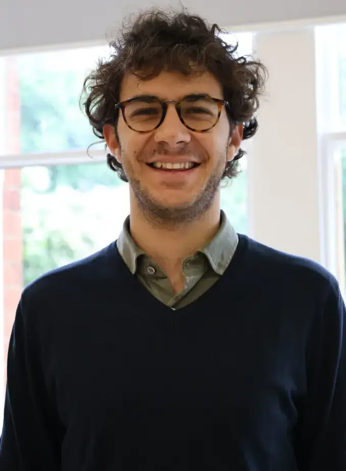 Male student wearing a black sweater and glasses