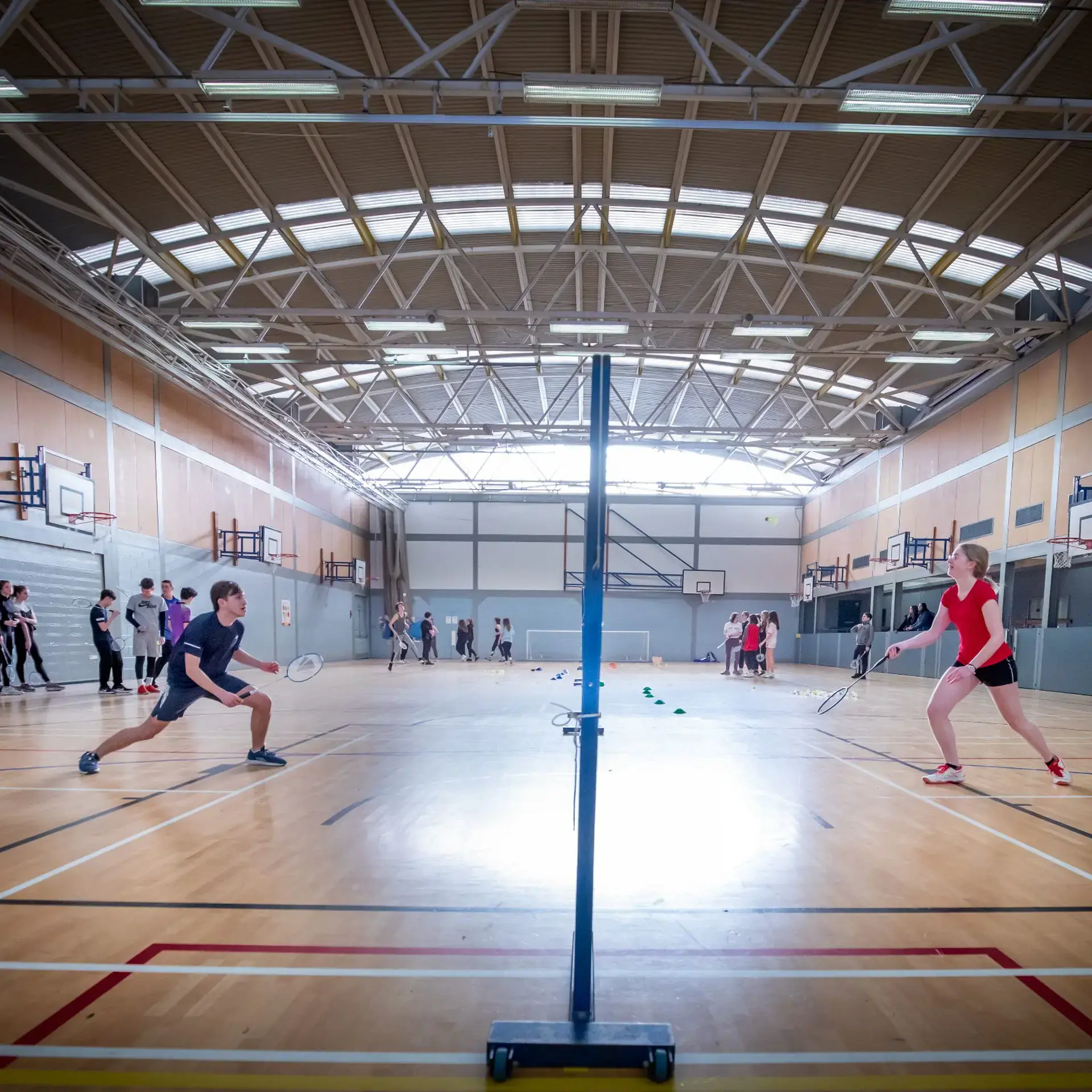 Students playing badminton in gym