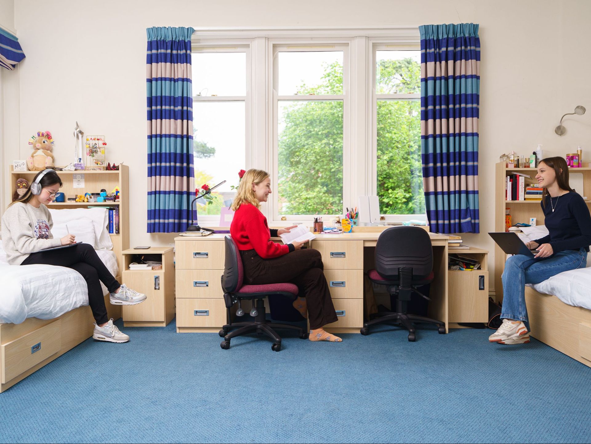 Three students chatting in twin bedroom
