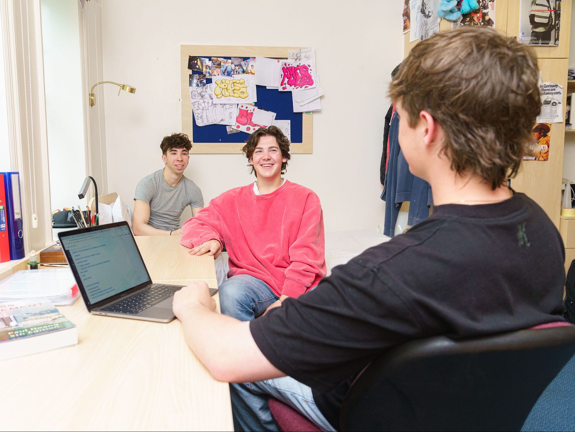 Three students having a conversation and smiling