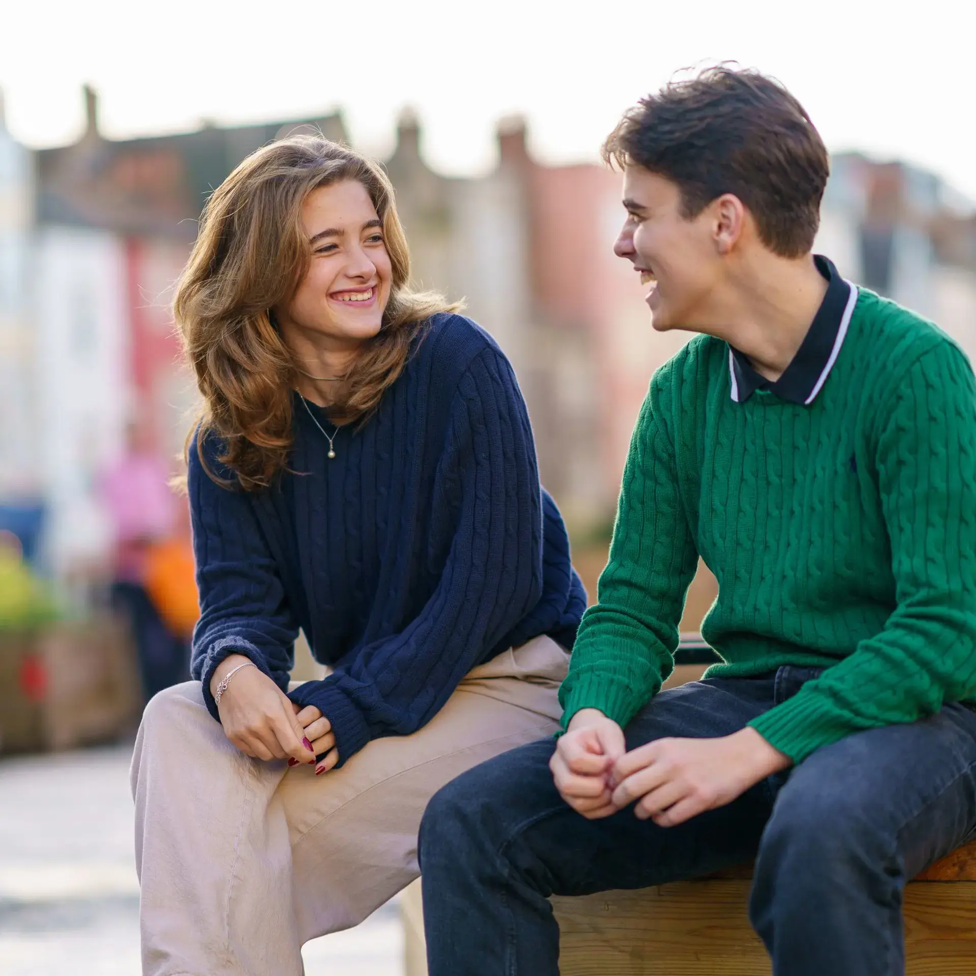 Two students chatting on bench outside