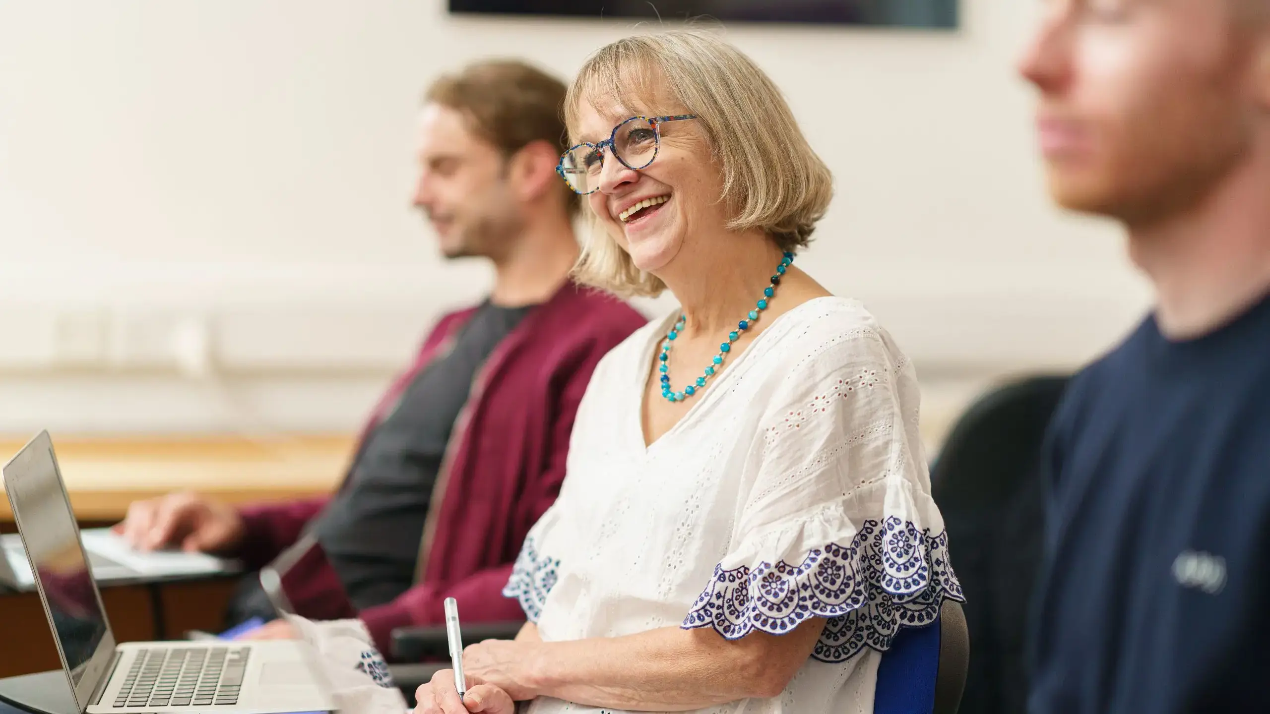Teacher smiling up from their work during seminar
