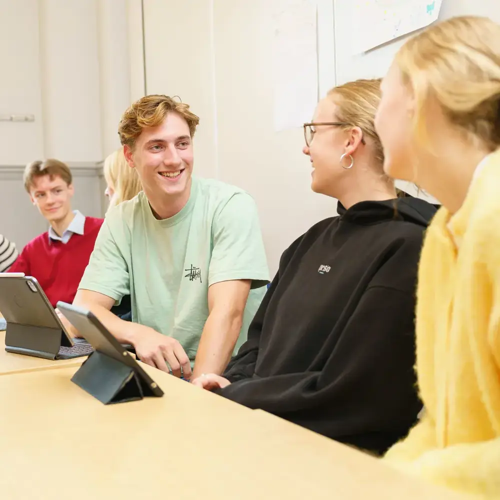 Students working together in class on tablet