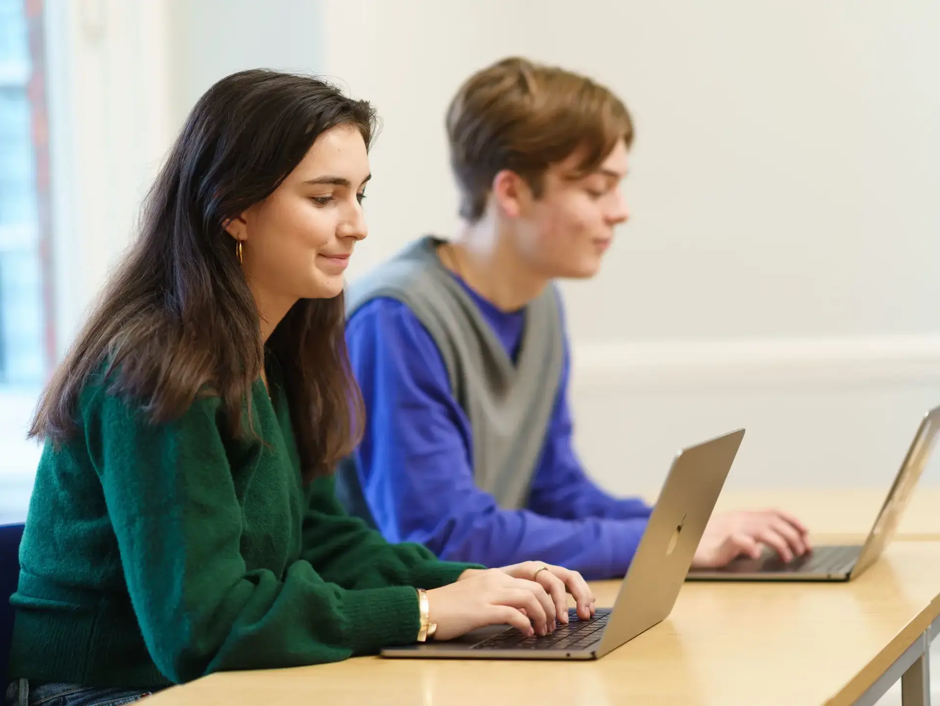 Two students working at laptops