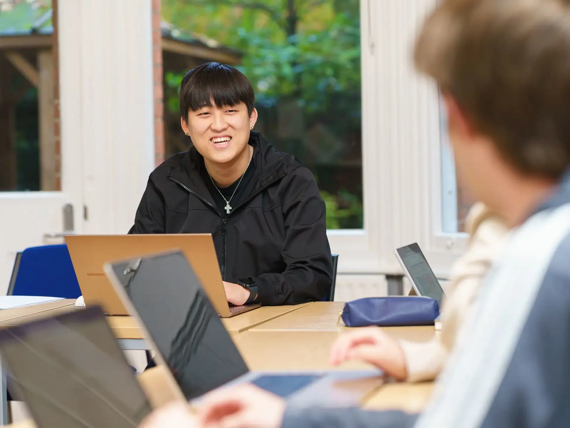 Student looking up from tablet, smiling