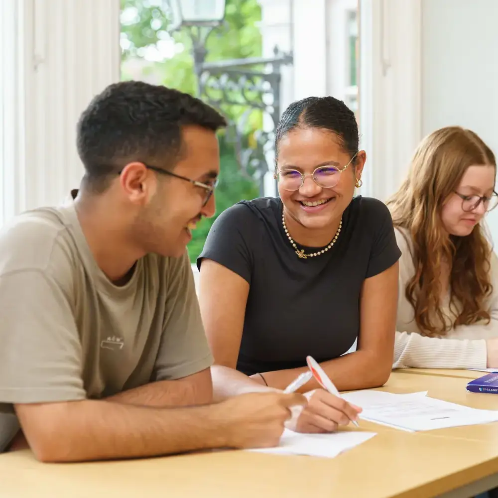 Students talking and smiling in class while doing classwork
