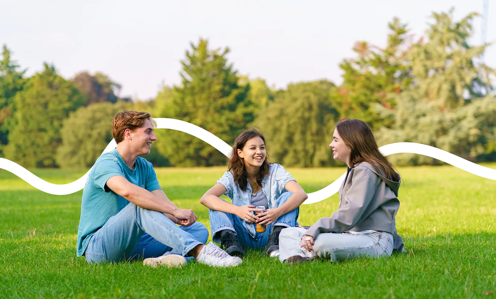 Students in field sitting and chatting together