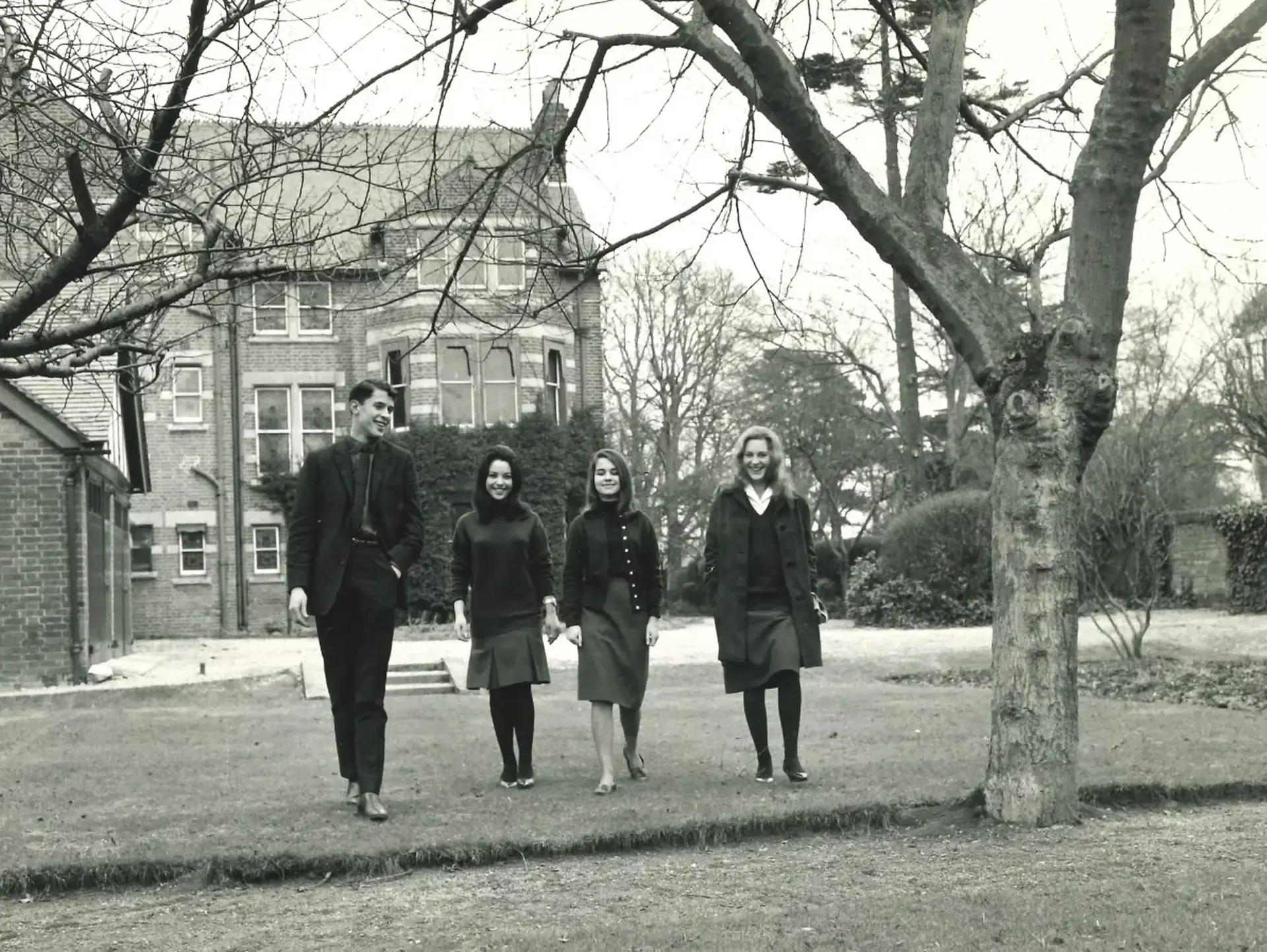 Black and white photo of students walking through campus