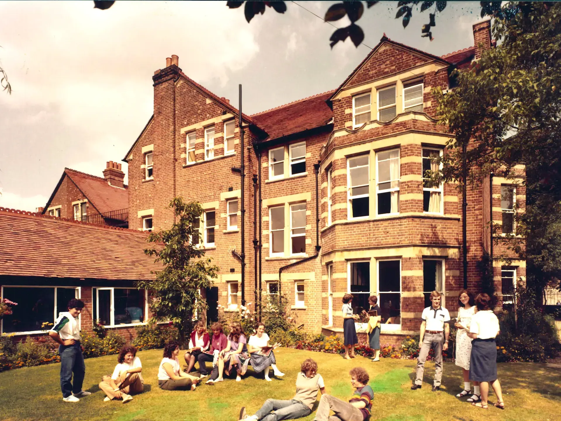 Older photograph of St Clare's students sitting on lawn outside school
