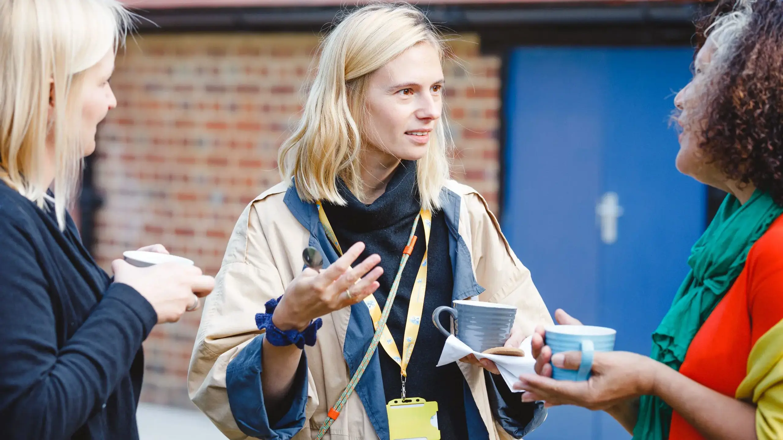 Teachers chatting outside holding cups of tea