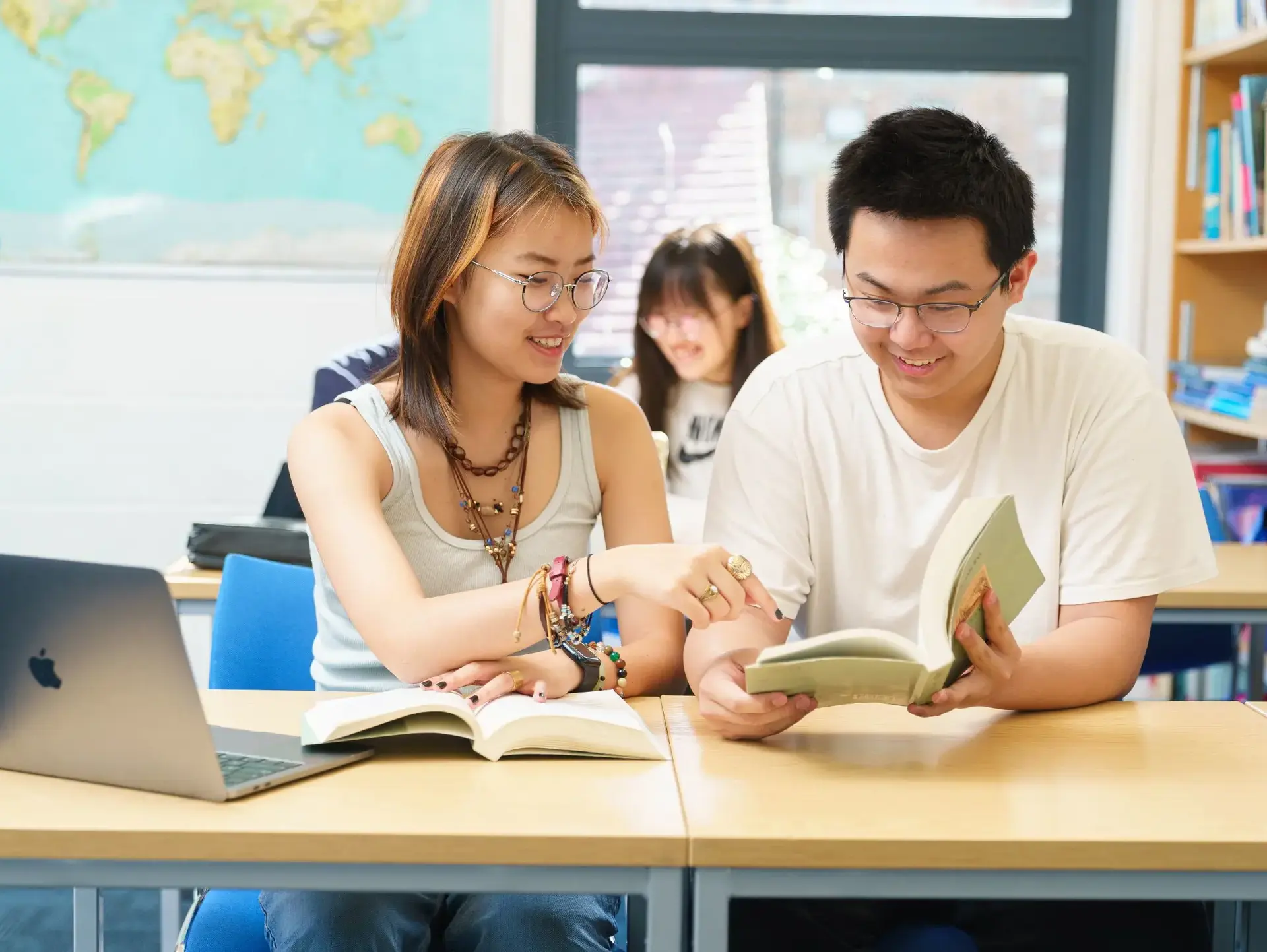 Students smiling over open book