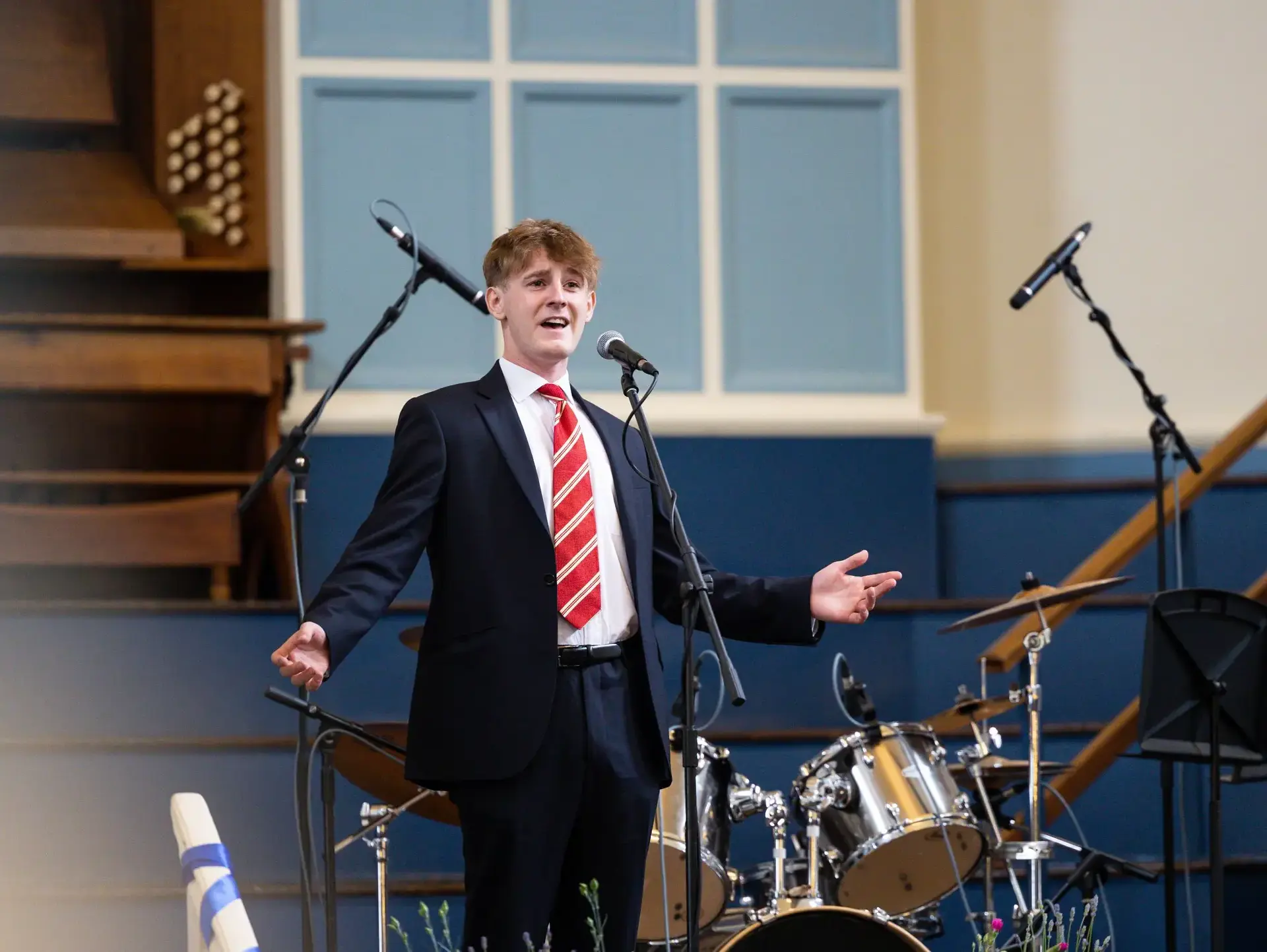Student performing onstage, arms outspread