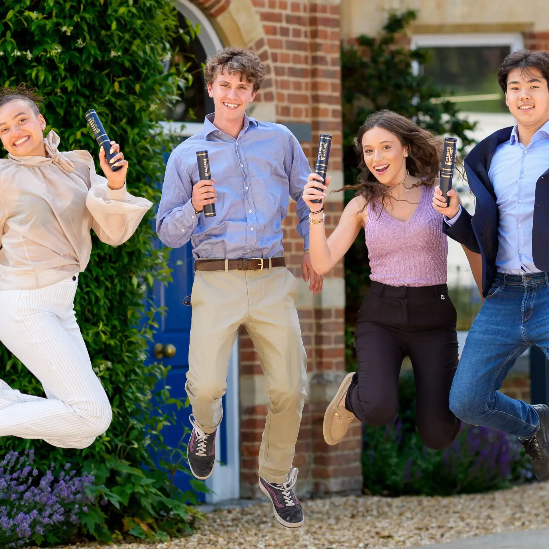 Graduating students jumping, holding diplomas