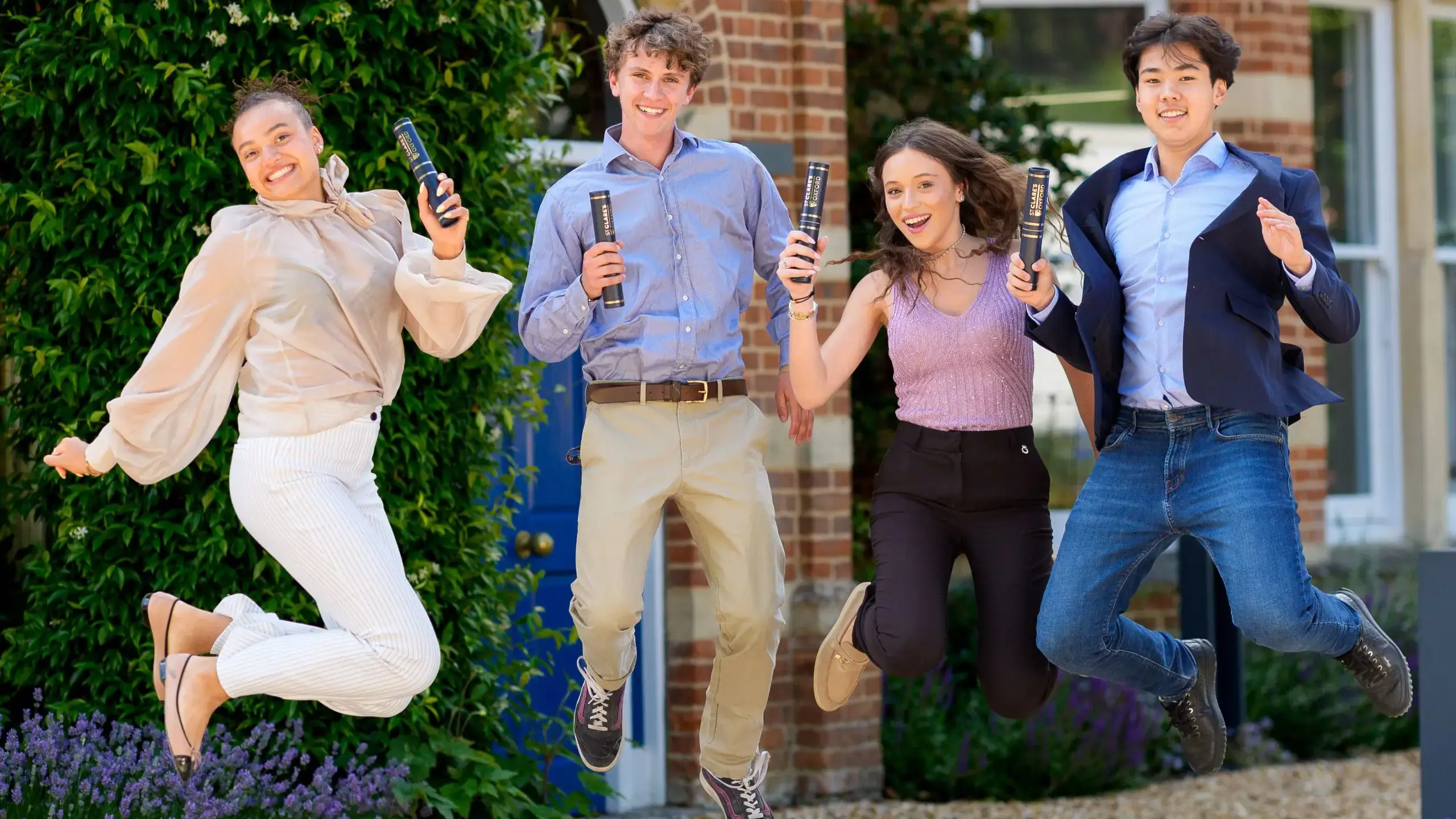 Graduating students jumping, holding diplomas