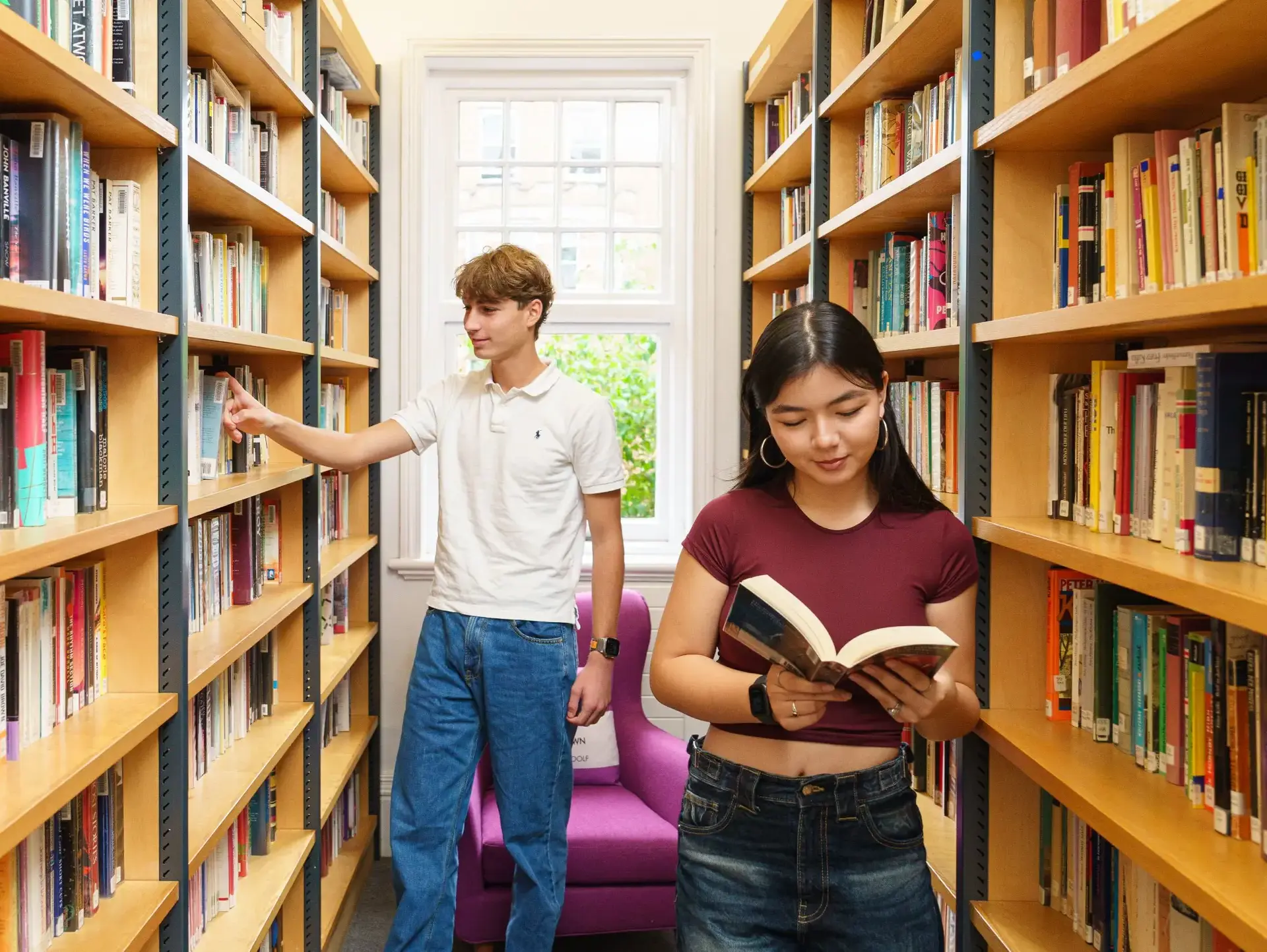 Students between library shelves