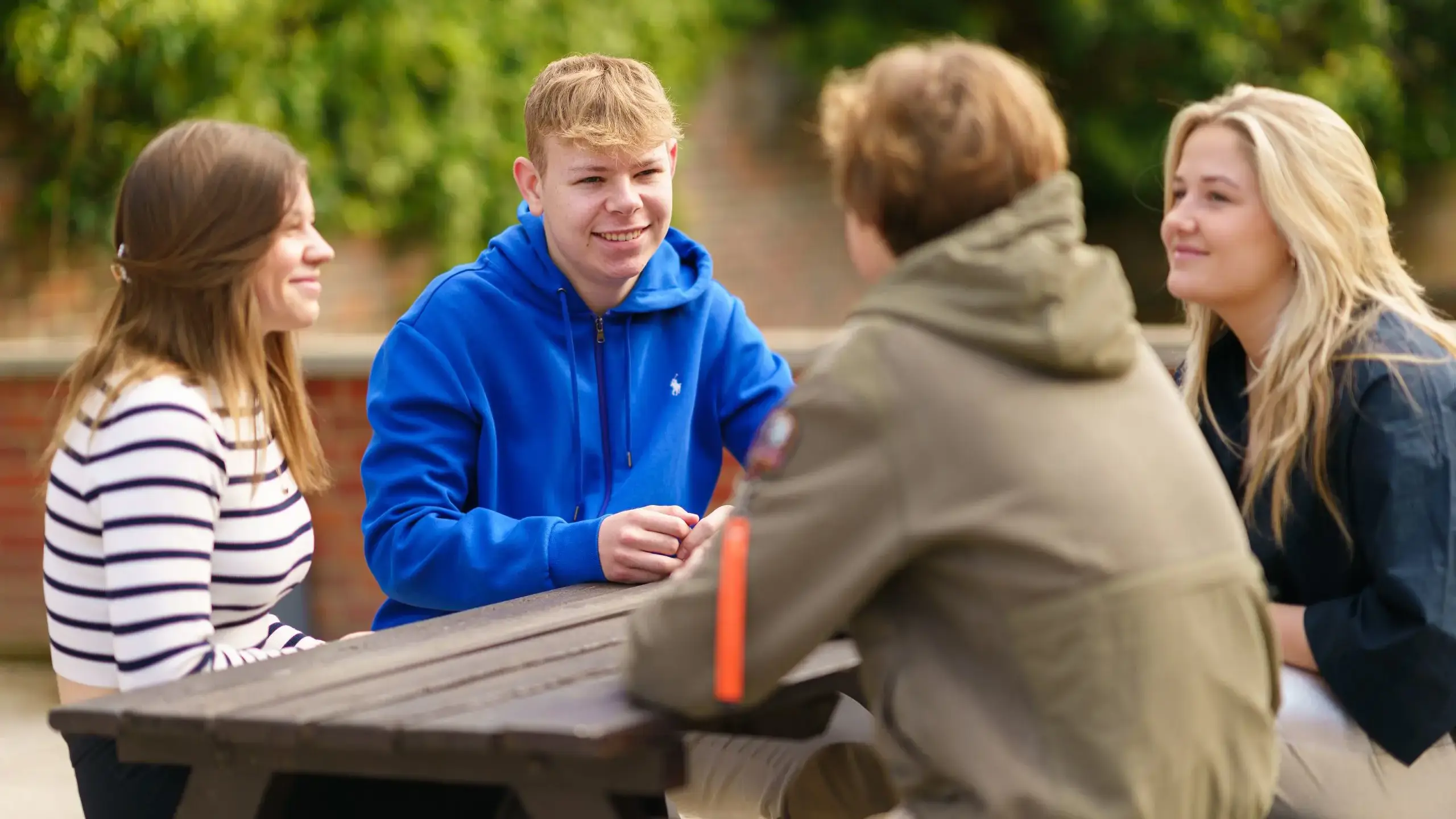 Four students sitting and picnic table