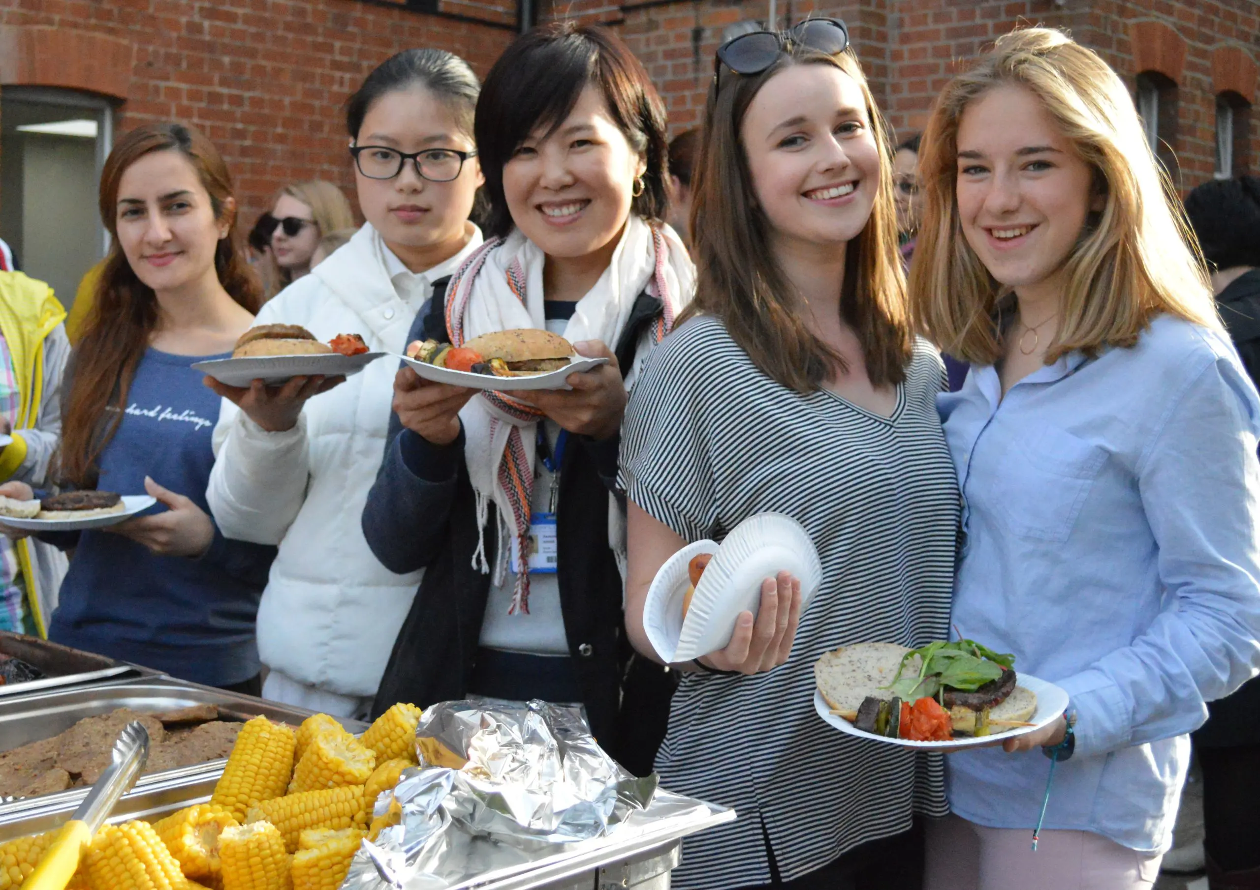 Students posing with food on paper plates