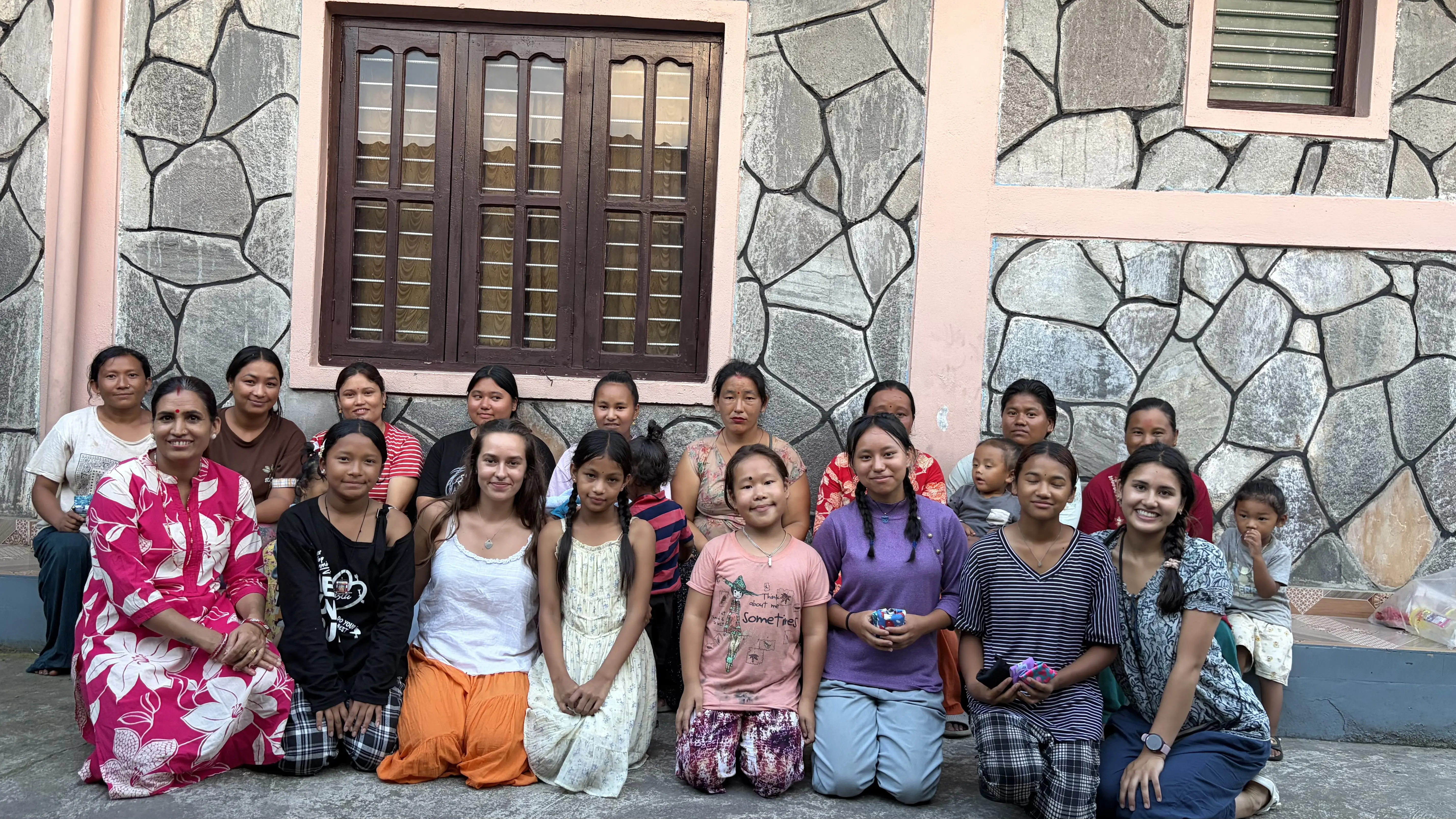 Alumna Emilia smiling with a group of women and young girls in Nepal
