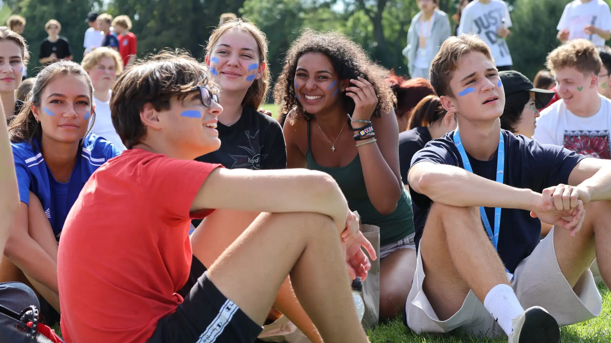 Students sitting on grass, looking upwards
