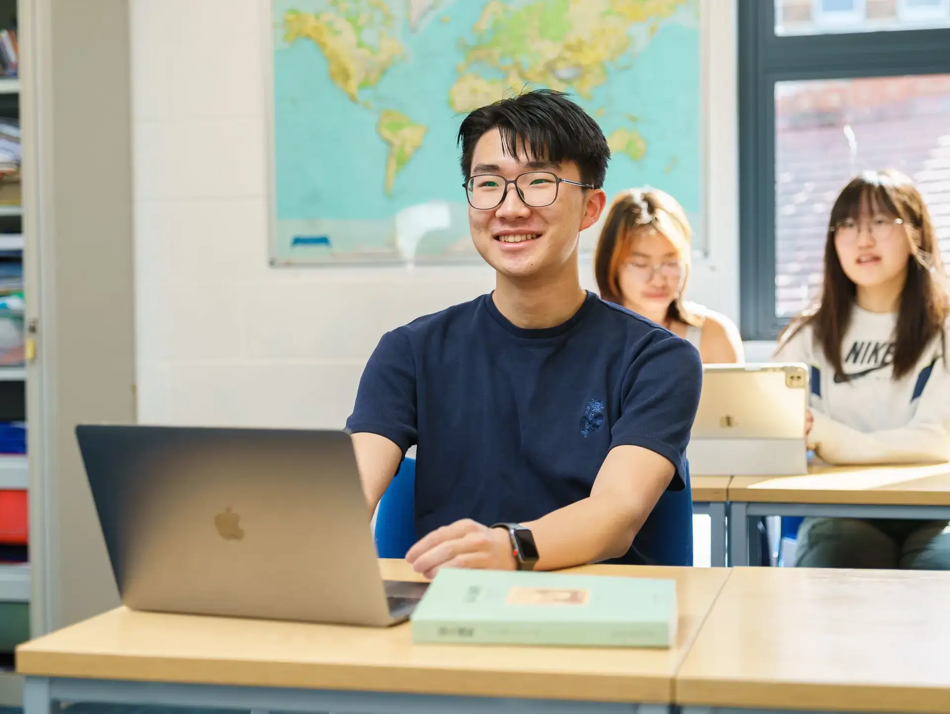 Smiling student working at laptop