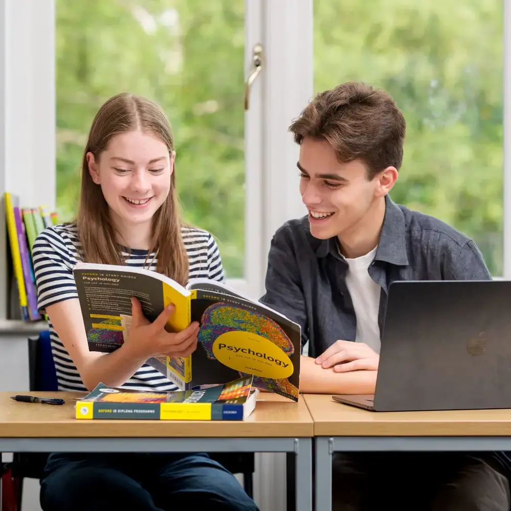 Students reading booklet together in class