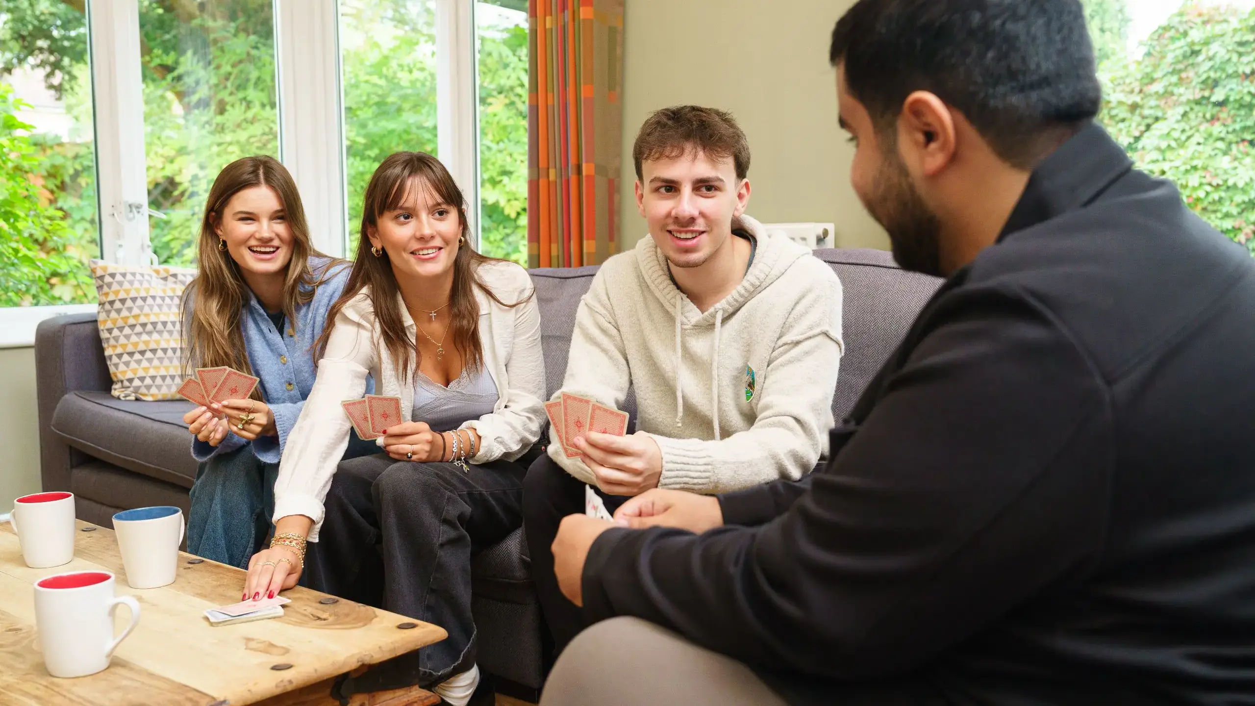 Four students chatting on sofa