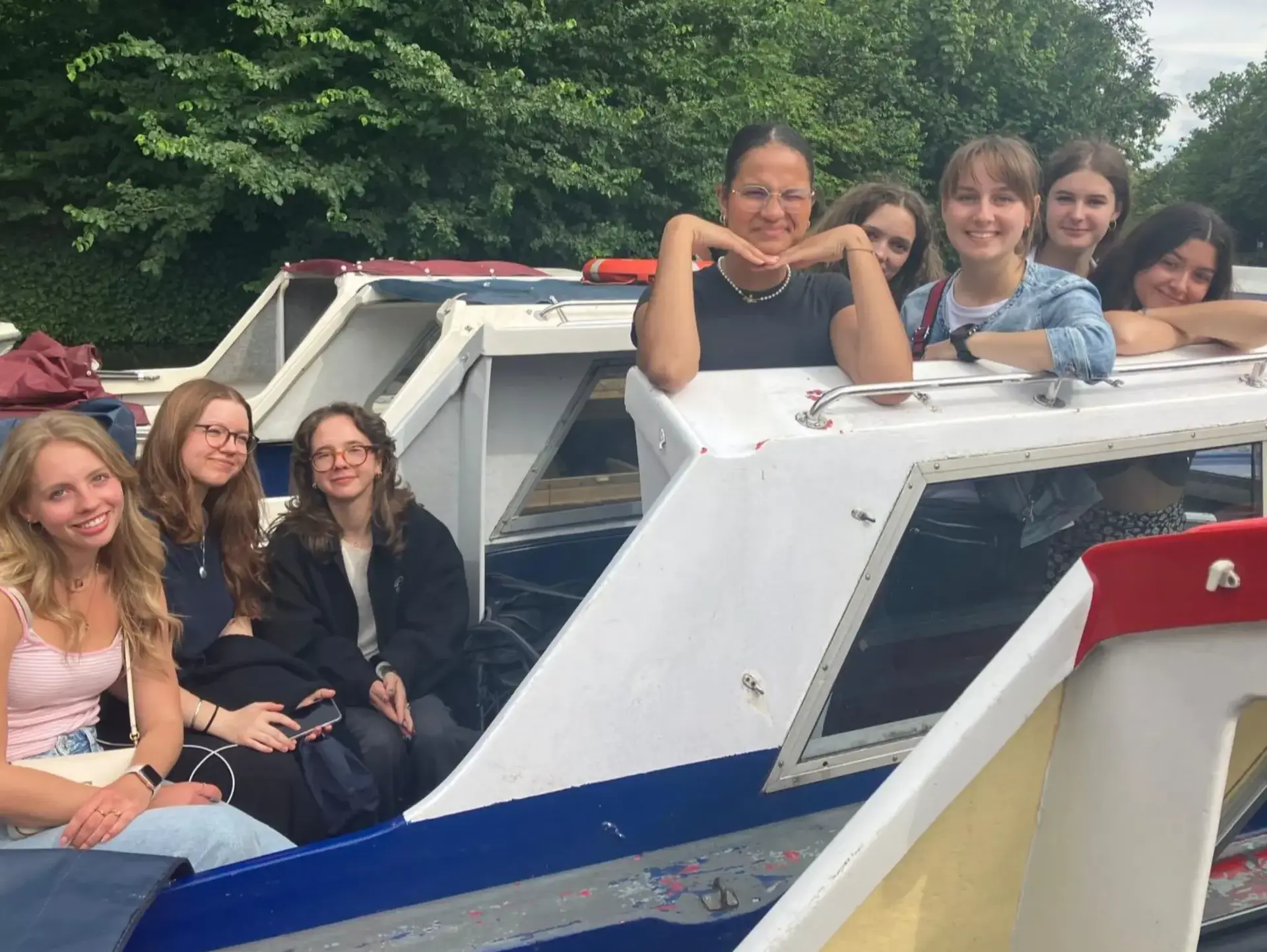 Group of students sitting on small boat