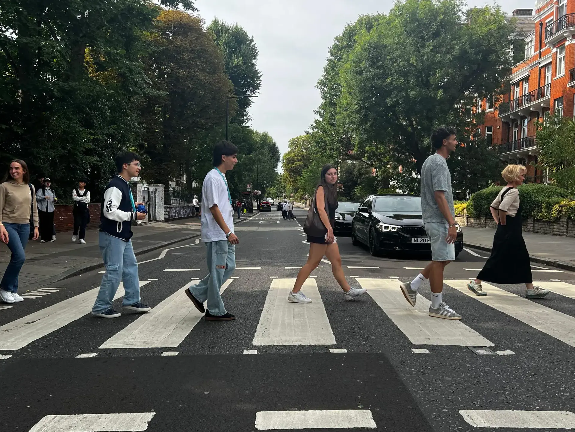 Students recreating the Abbey Road photo, walking across a zebra crossing