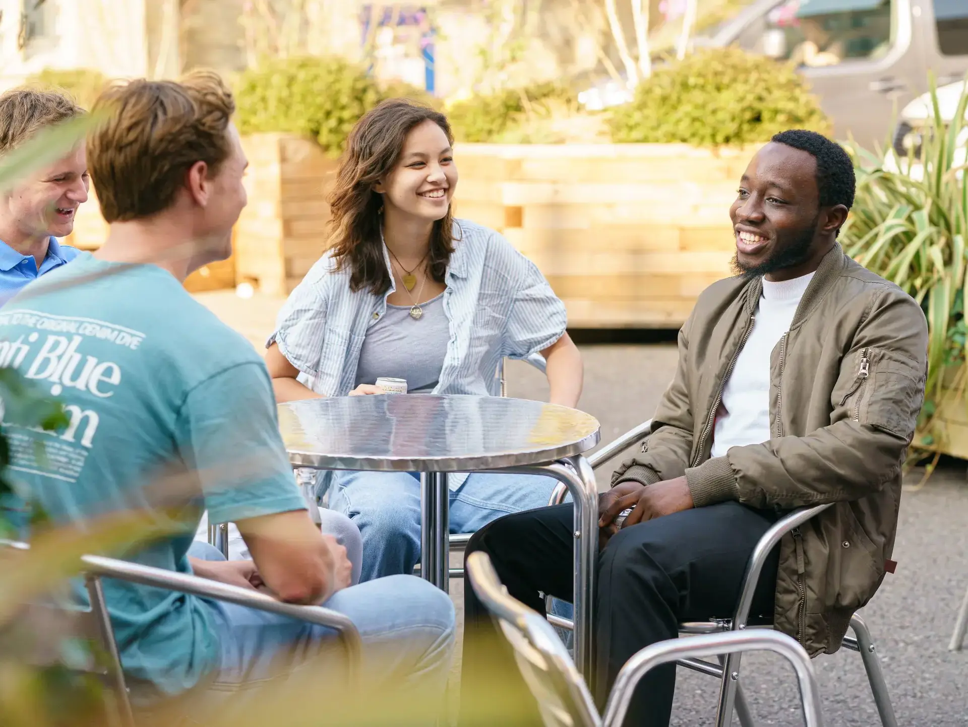 Four students sitting outdoors at a cafe