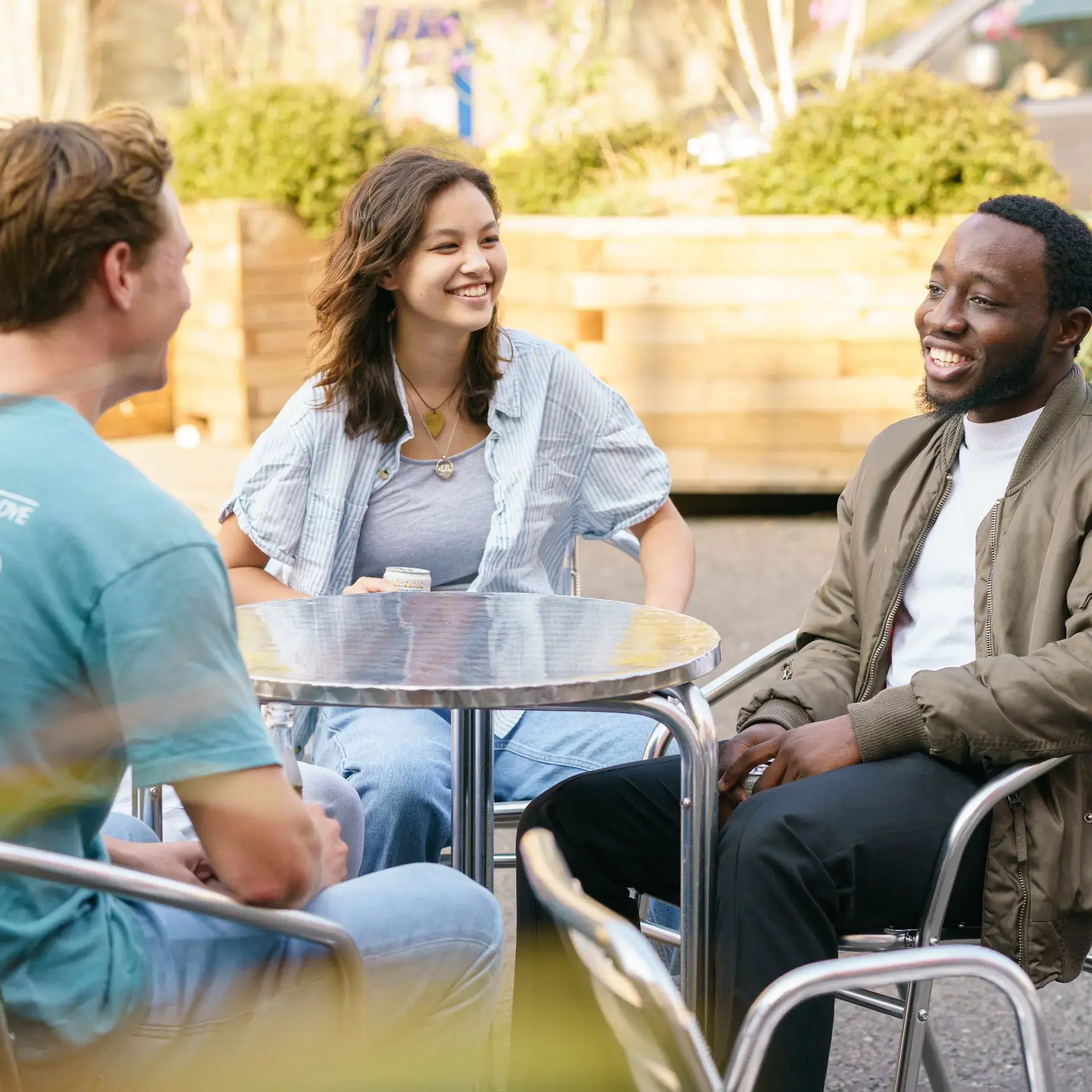 Students sitting at table and chatting outdoors