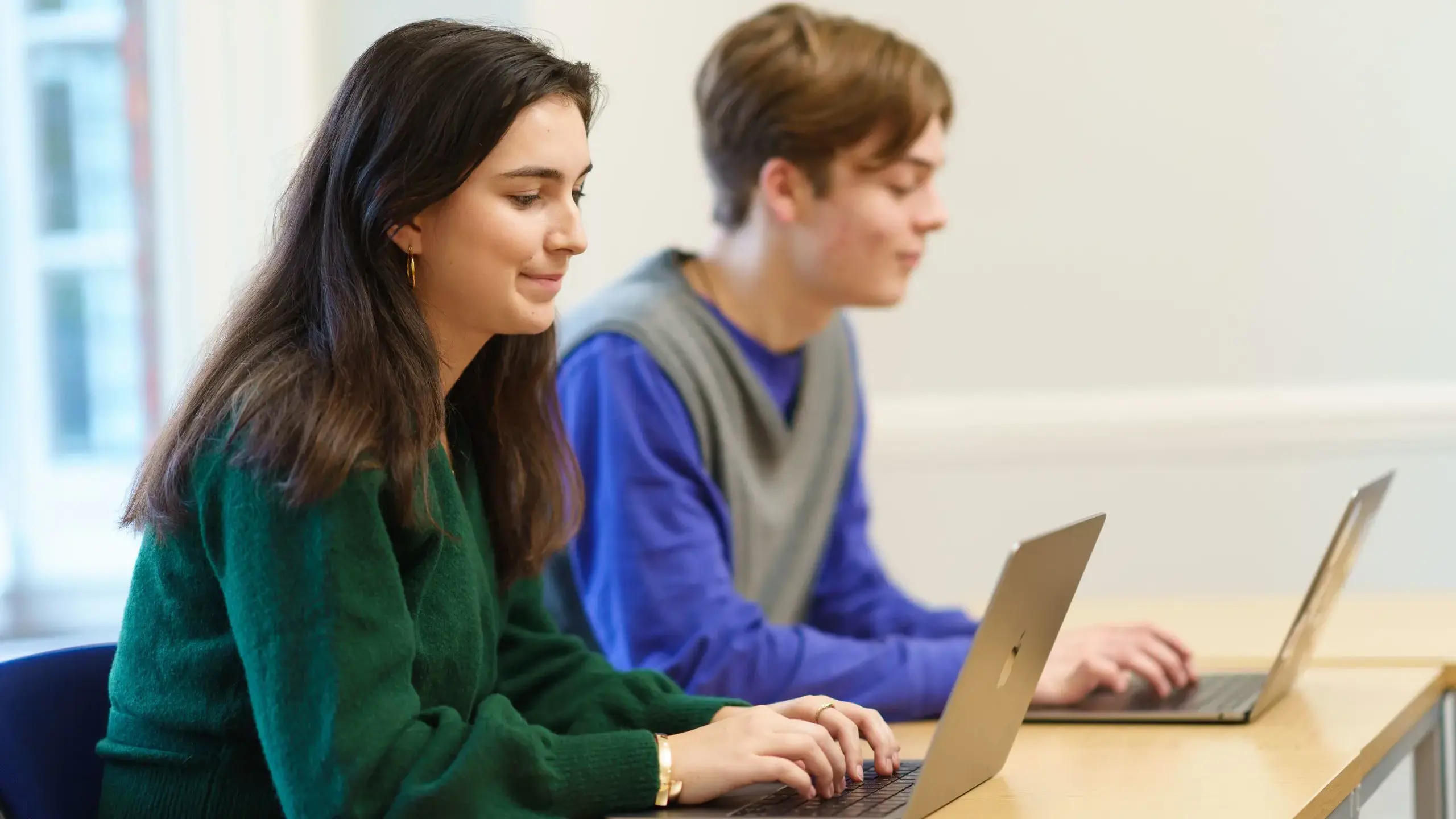 Two students working at laptops