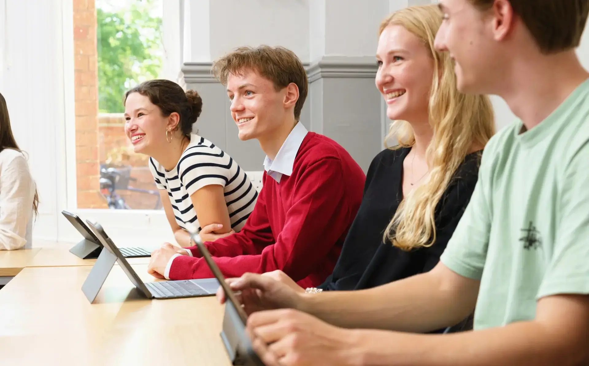 Students smiling up from desk