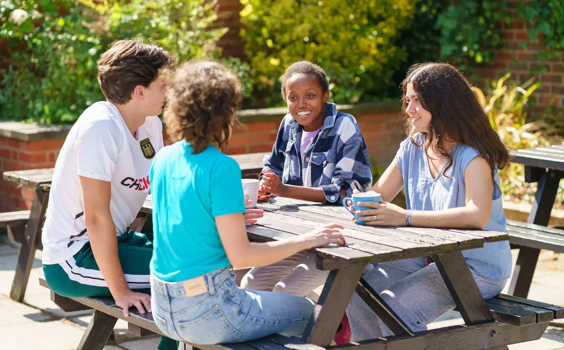 Four students sitting at a picnic table