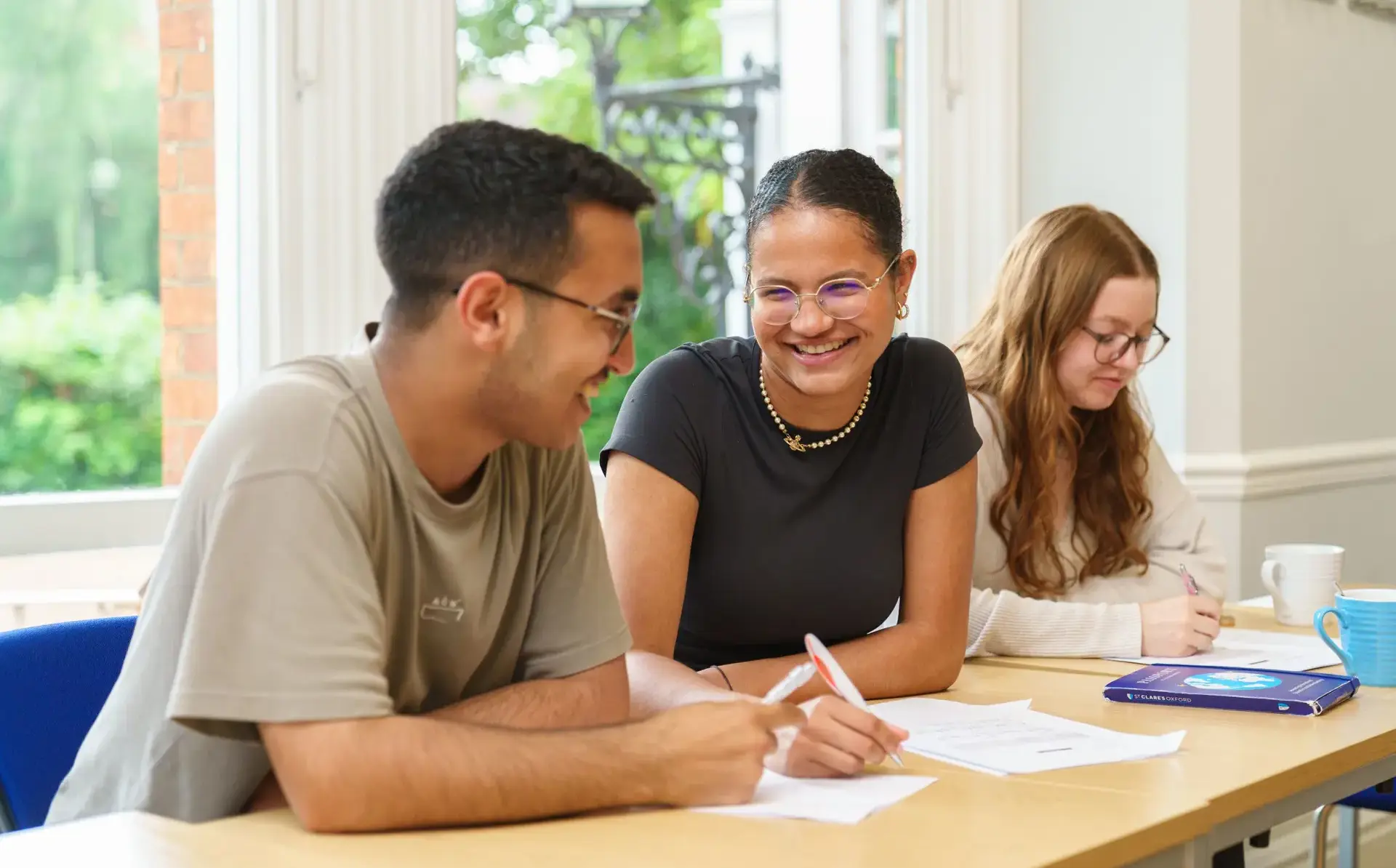 Students sitting at desk, laughing