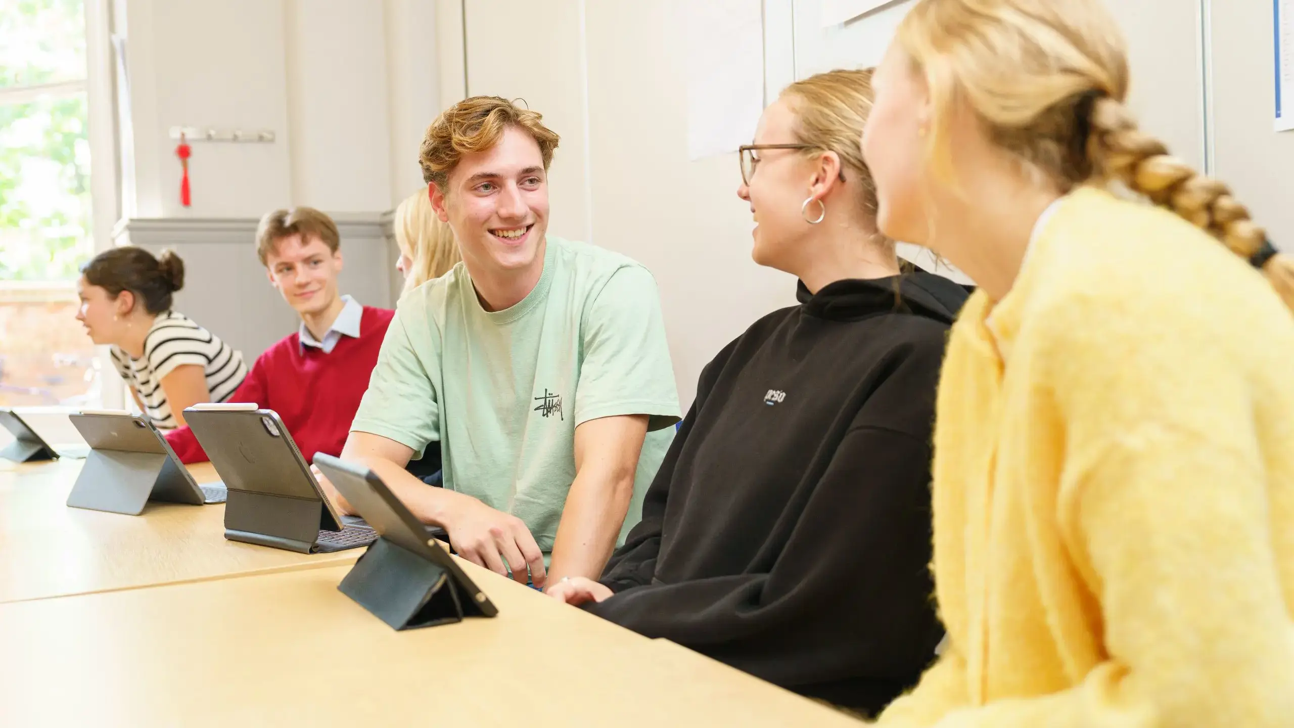 Students sitting at desk, chatting