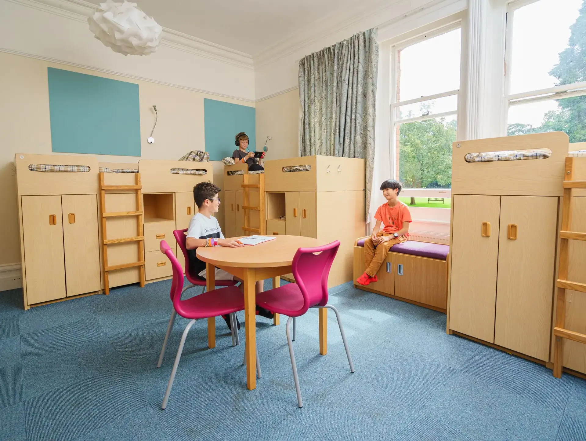 Students sitting in triple bedroom