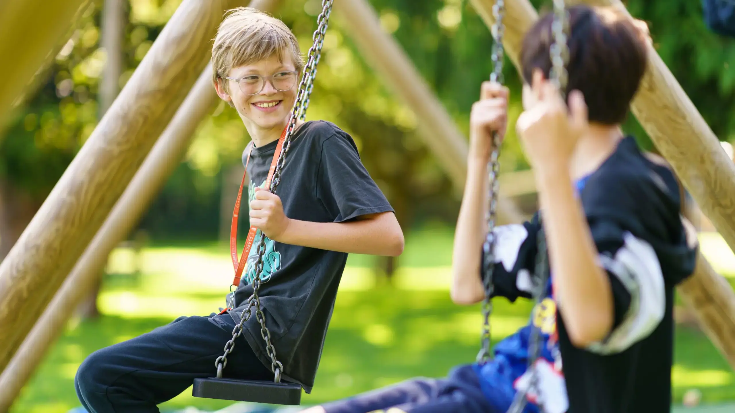 Students sitting in swings