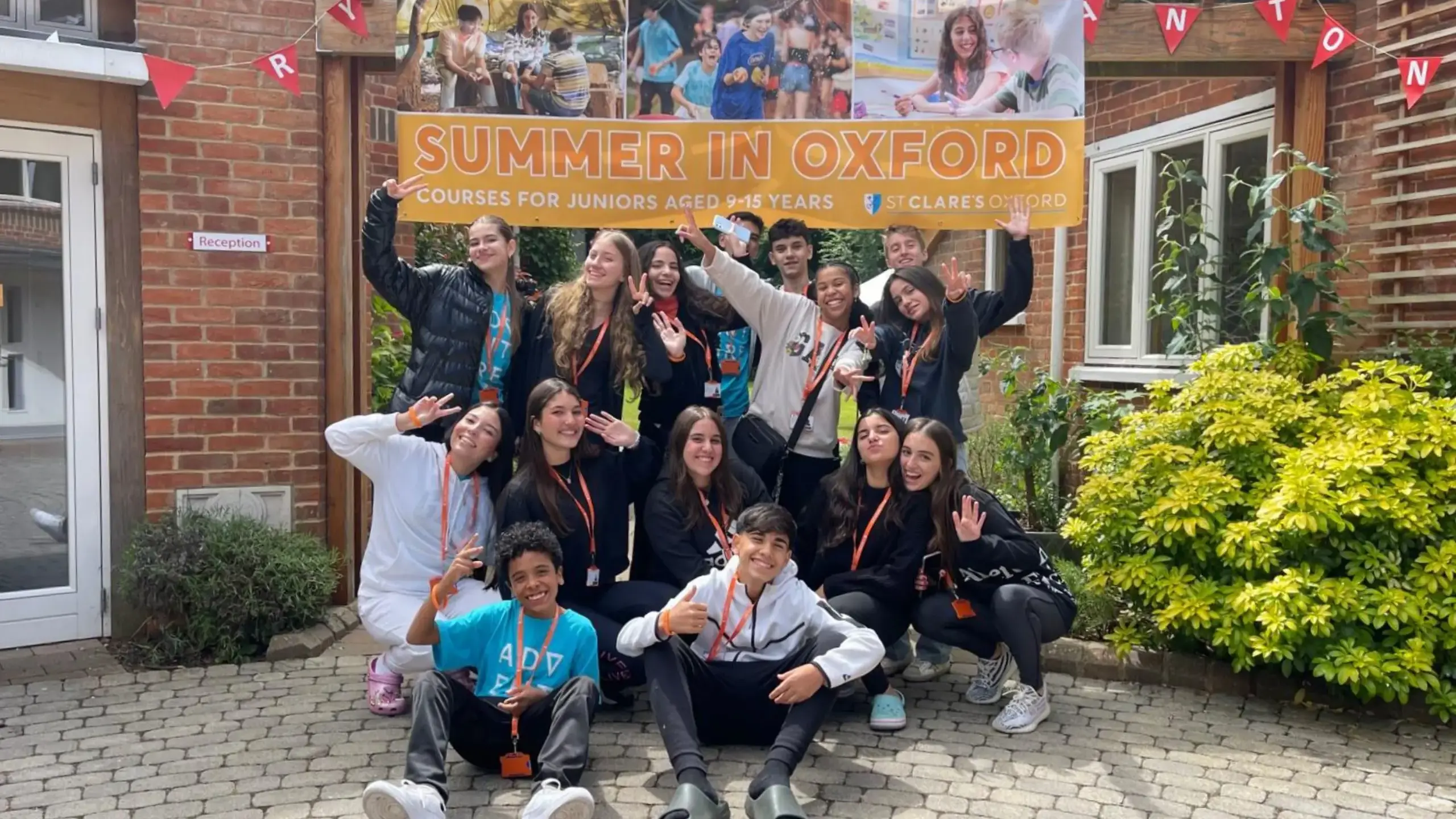 Group of students posing in front of St Clare's banner