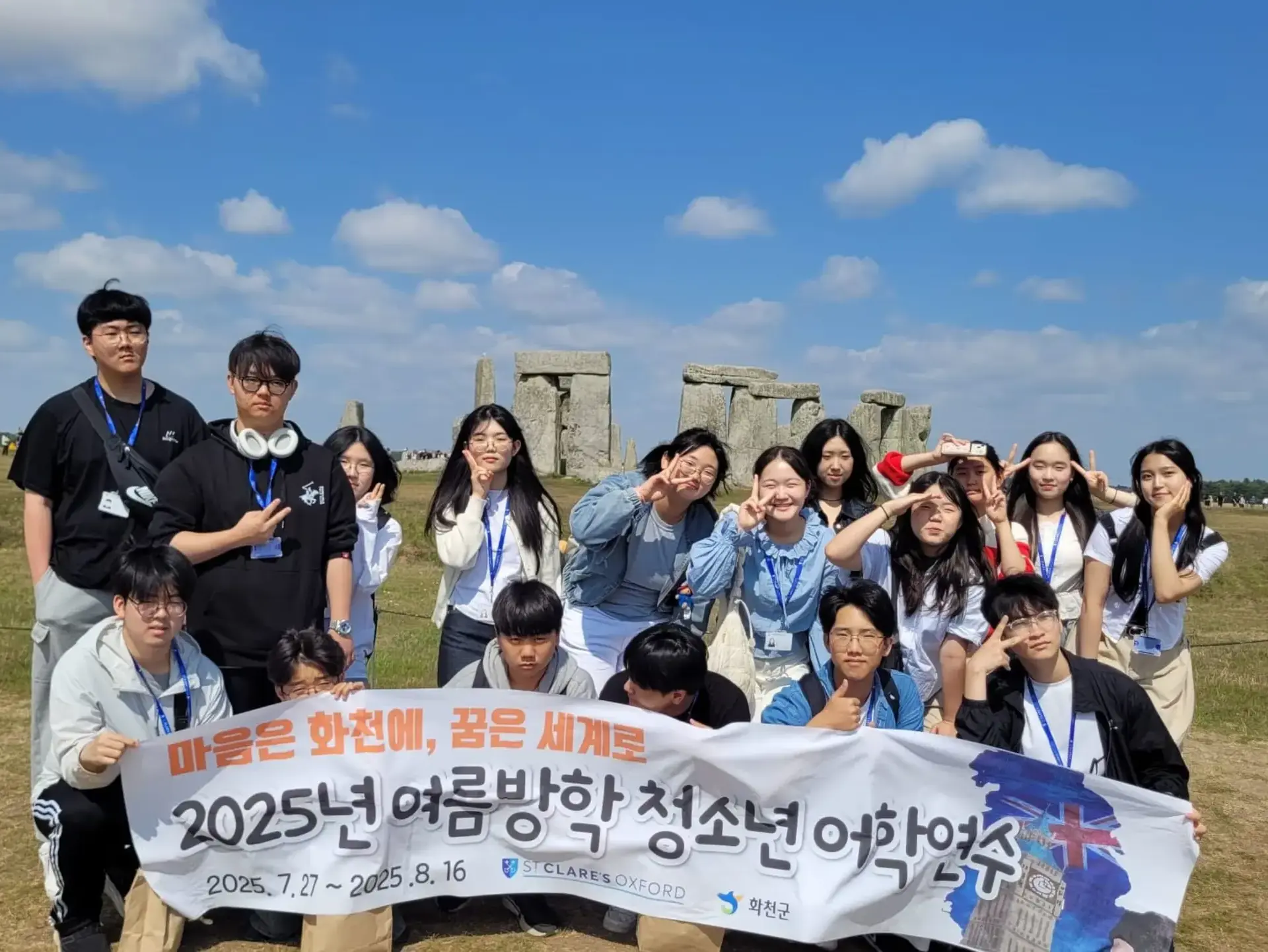 Students standing in front of Stonehenge, holding a Korean banner