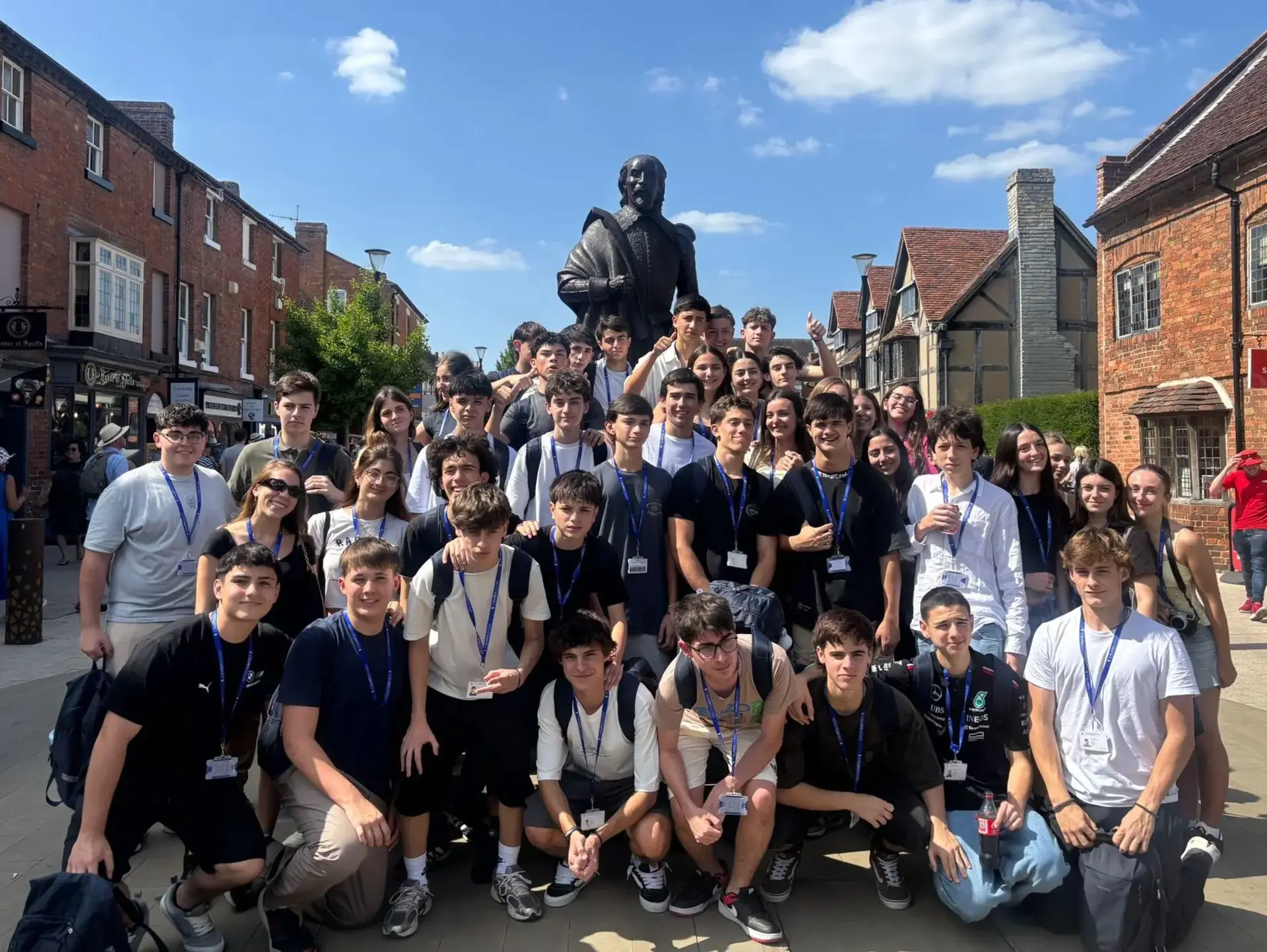 Students posing in front of statue of Shakespeare