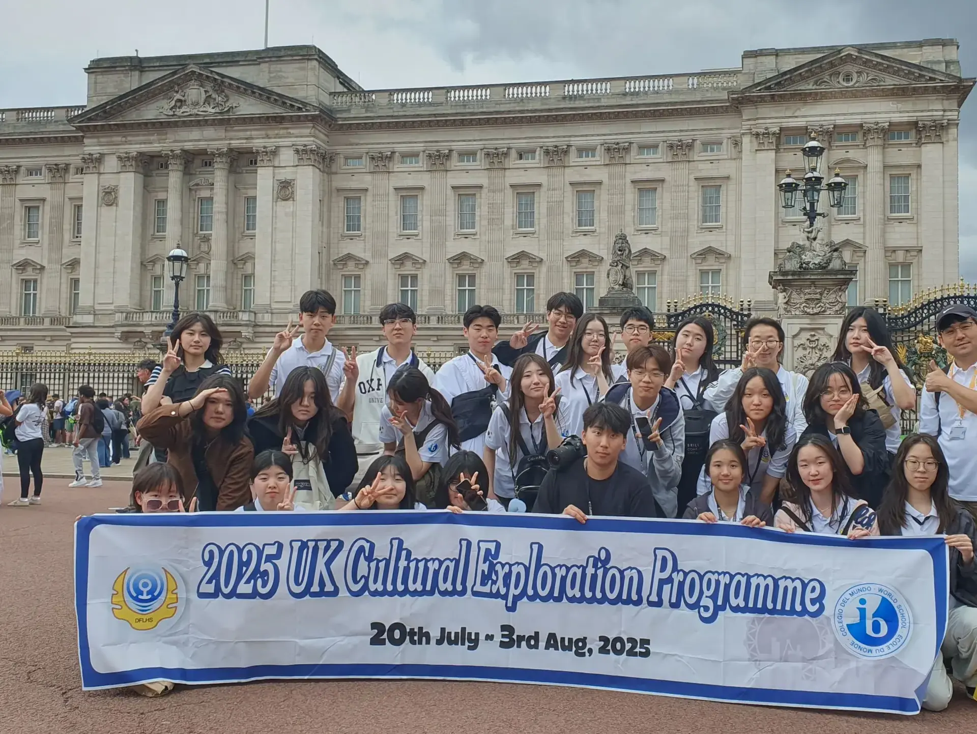 Students posing outside Buckingham Palace, holding Global Education Programme banner