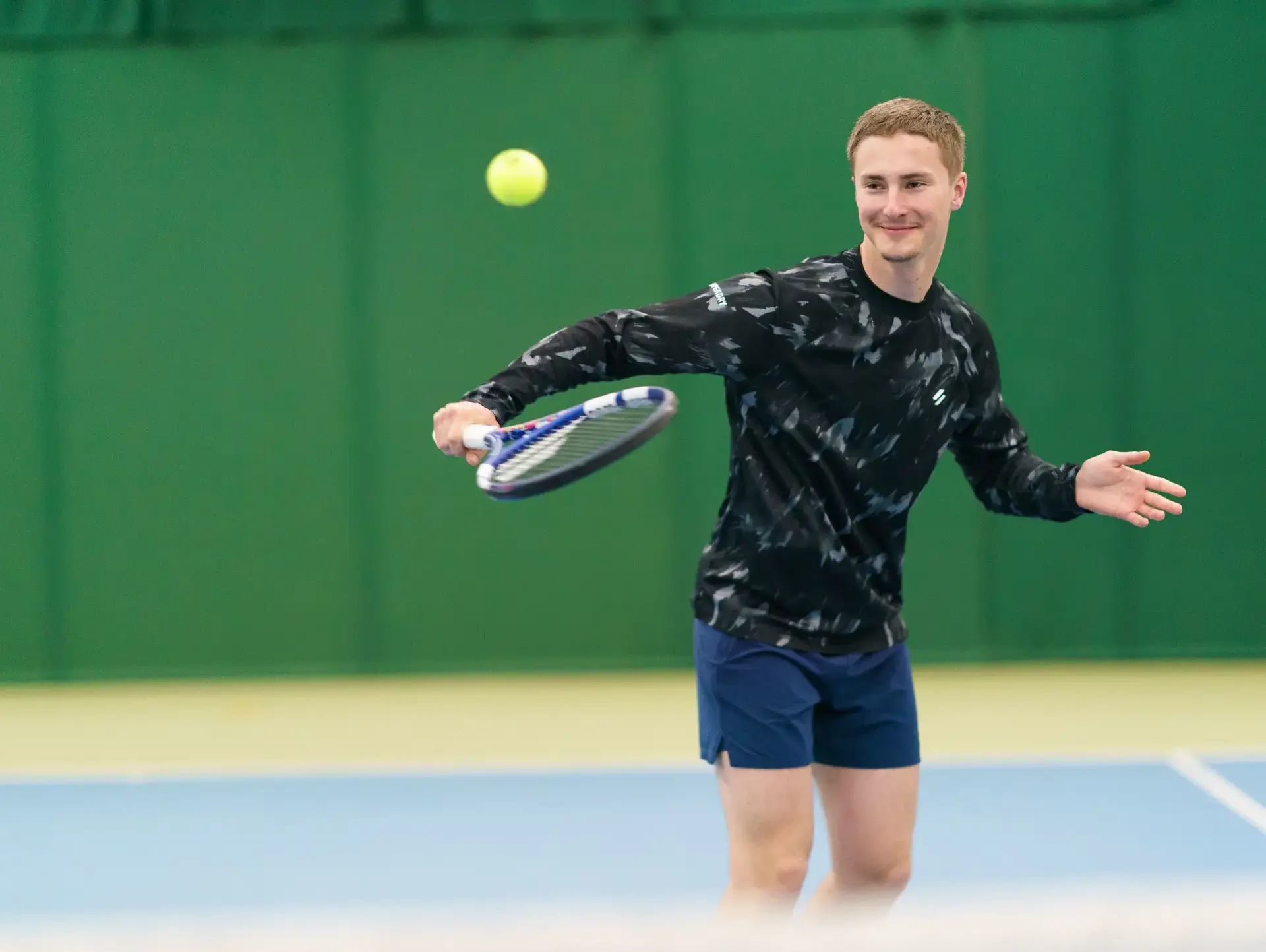 Student playing tennis