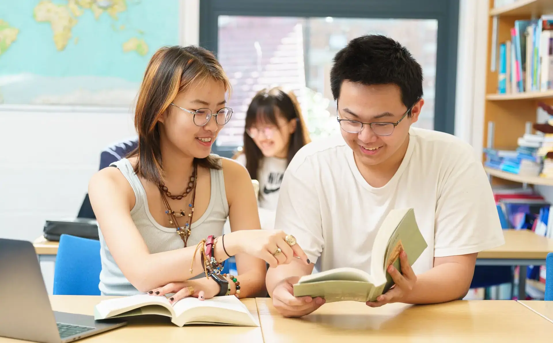 Students looking at open book on desk