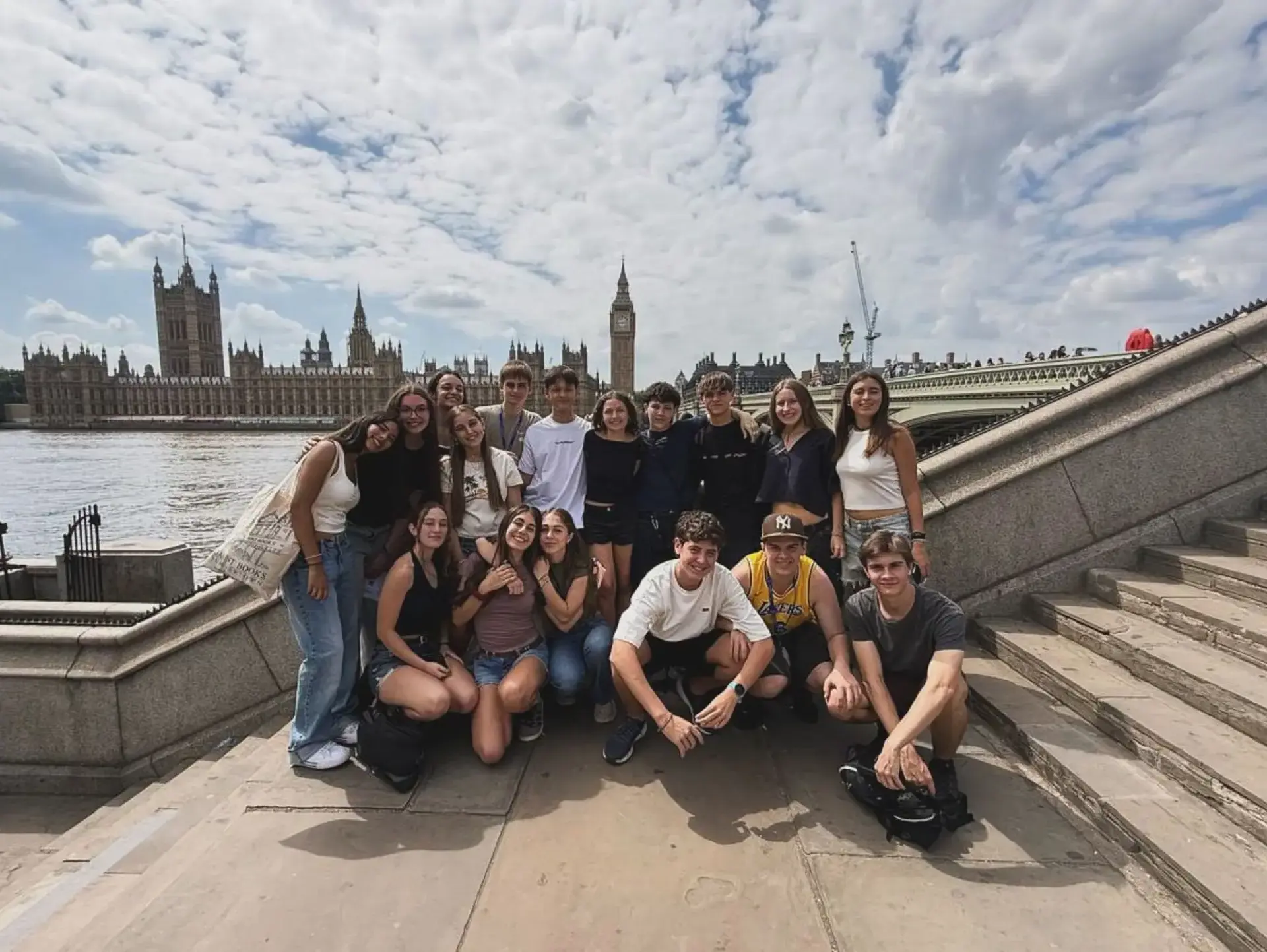 Students posing for photo with Houses of Parliament visible from across the river