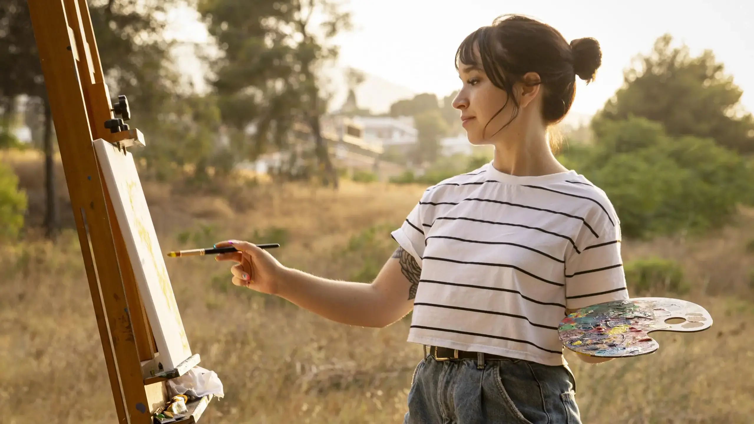Student painting at easel outside
