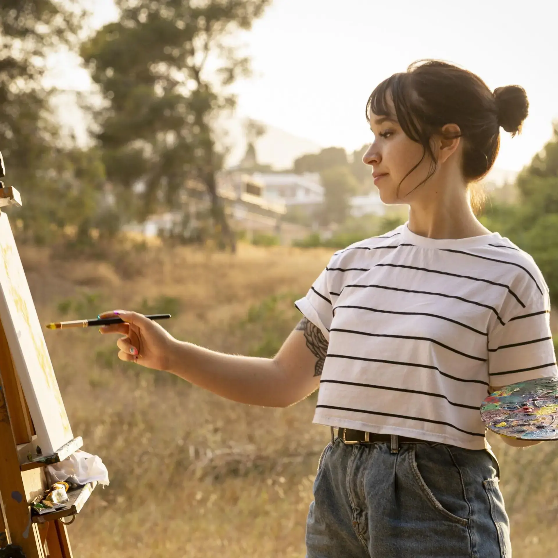 Student painting at easel outside
