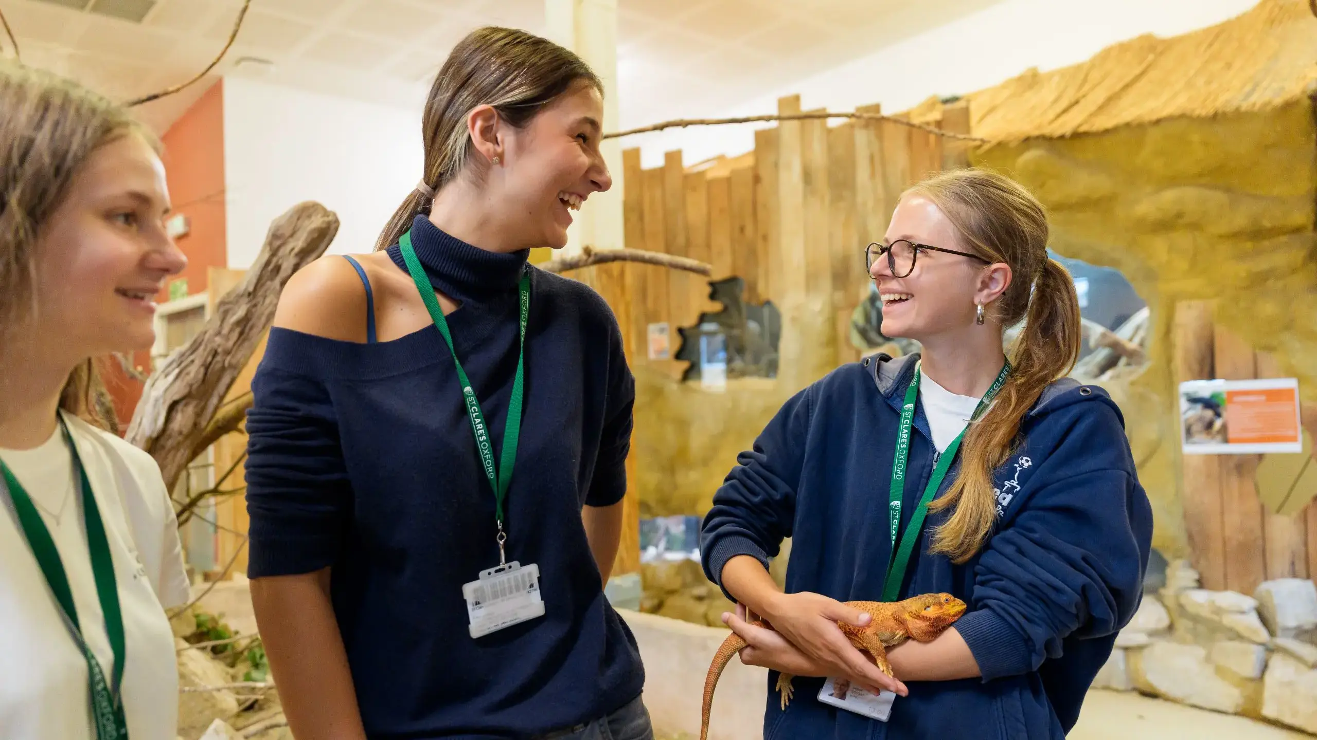 Students holding reptiles, chatting
