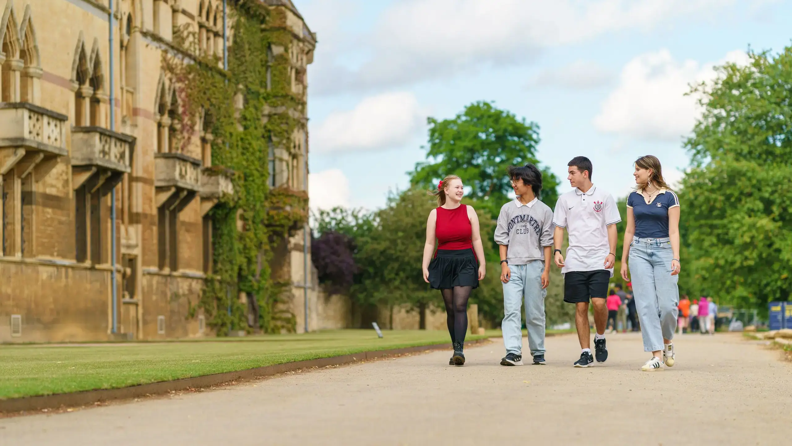 Four students walking along a path
