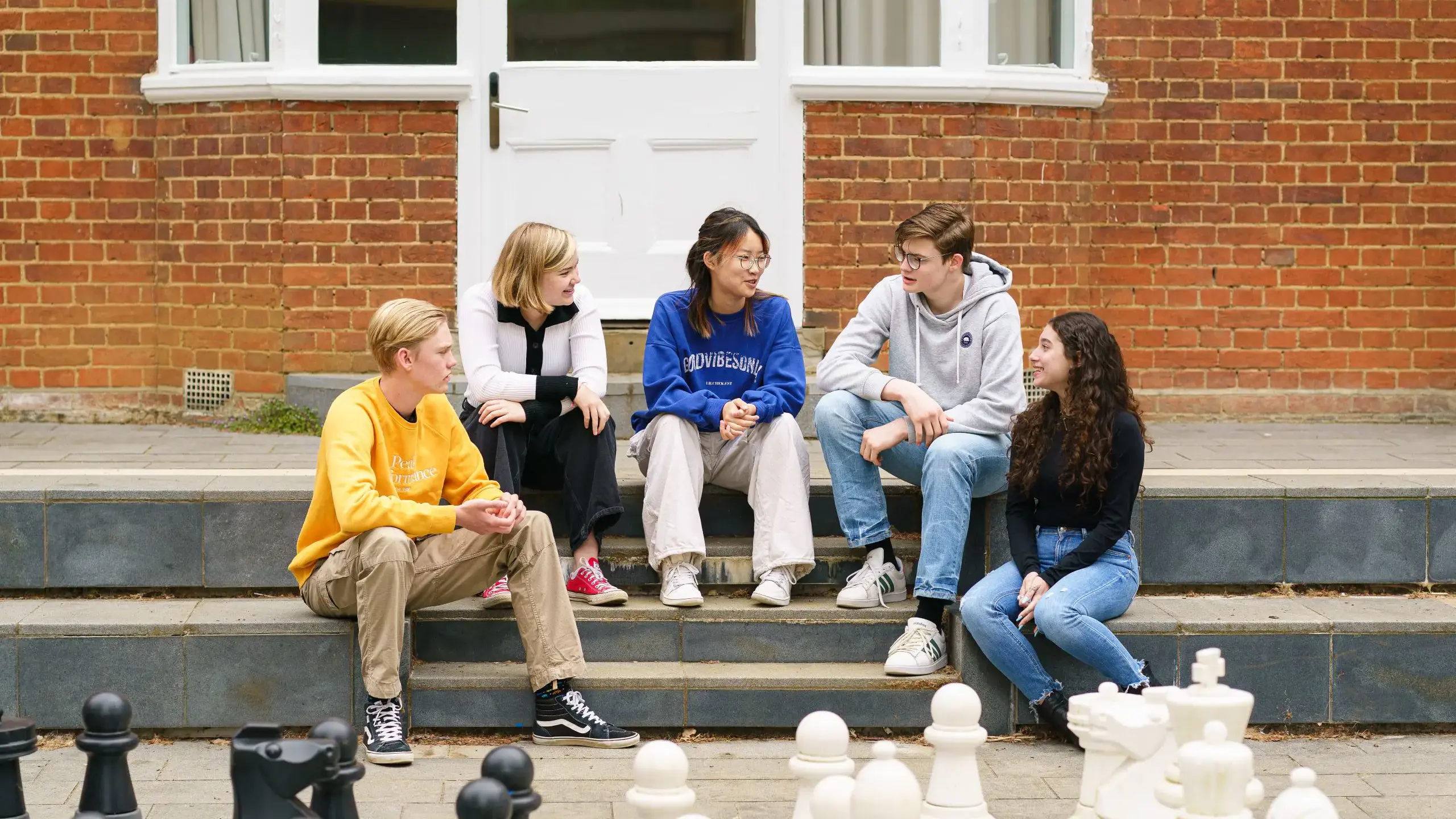 Students sitting on steps outside building